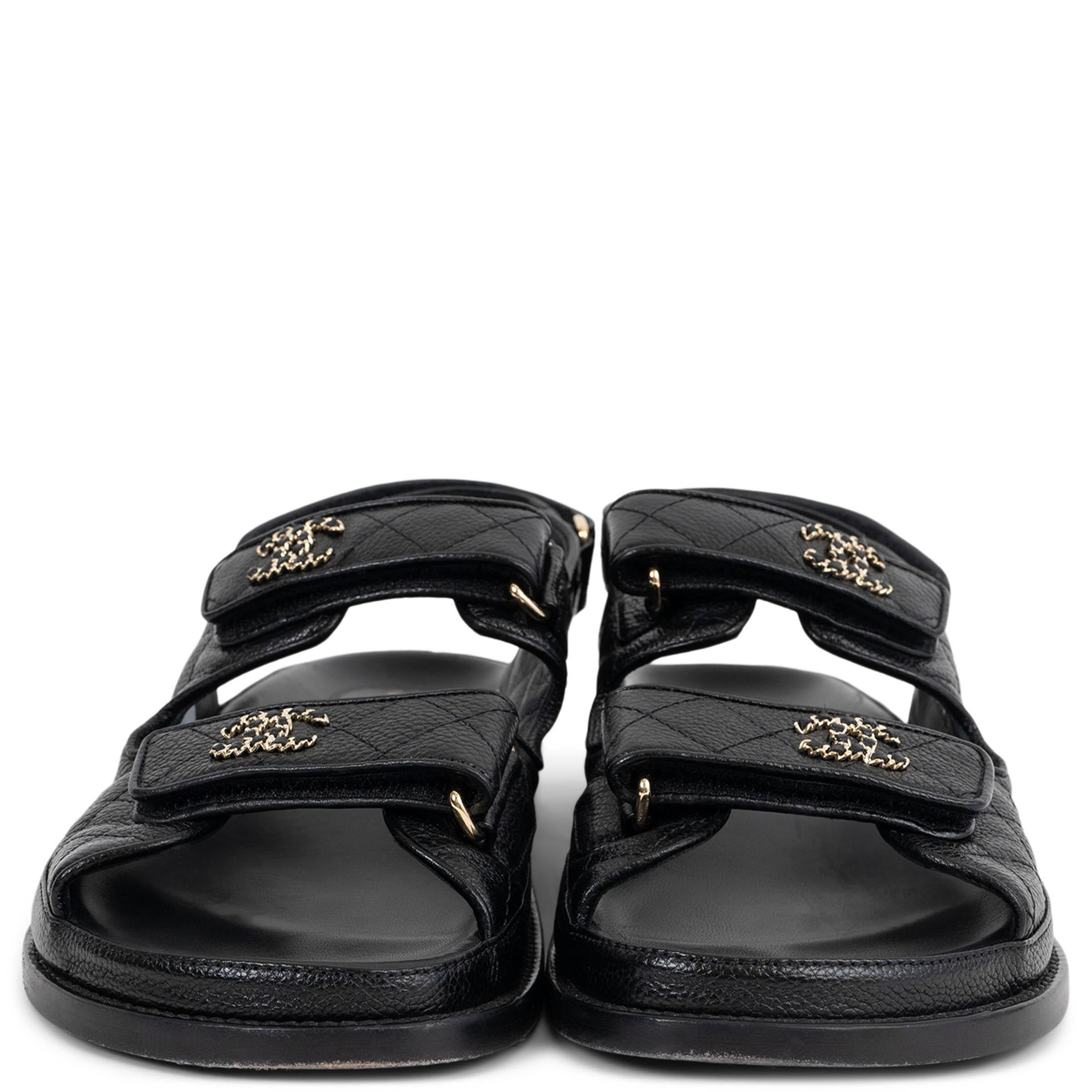 Diese 100% authentischen Chanel Dad Sandalen sind aus schwarzem, genarbtem Kalbsleder gefertigt und zeichnen sich durch eine unverwechselbare, lässige Silhouette aus. Zwei Klettverschlussriemen auf der Vorderseite sind mit goldfarbenen, in Leder
