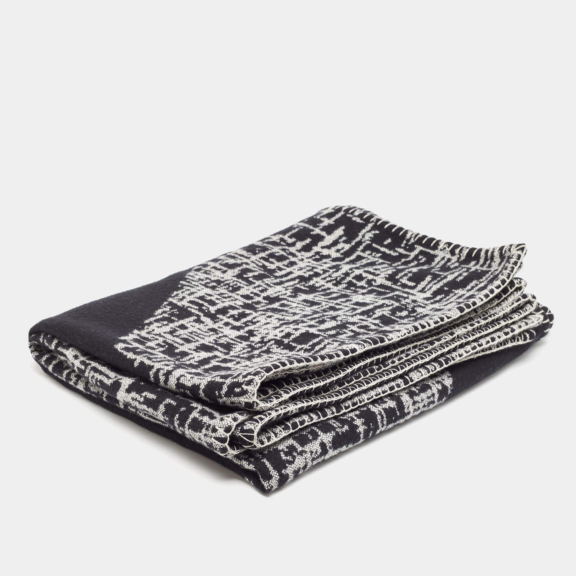 The Chanel throw blanket is a luxurious home accessory, seamlessly blending sophistication with comfort. Crafted from high-quality wool and adorned with a chic black and grey pattern, it offers a cozy, reversible design, making it a stylish and