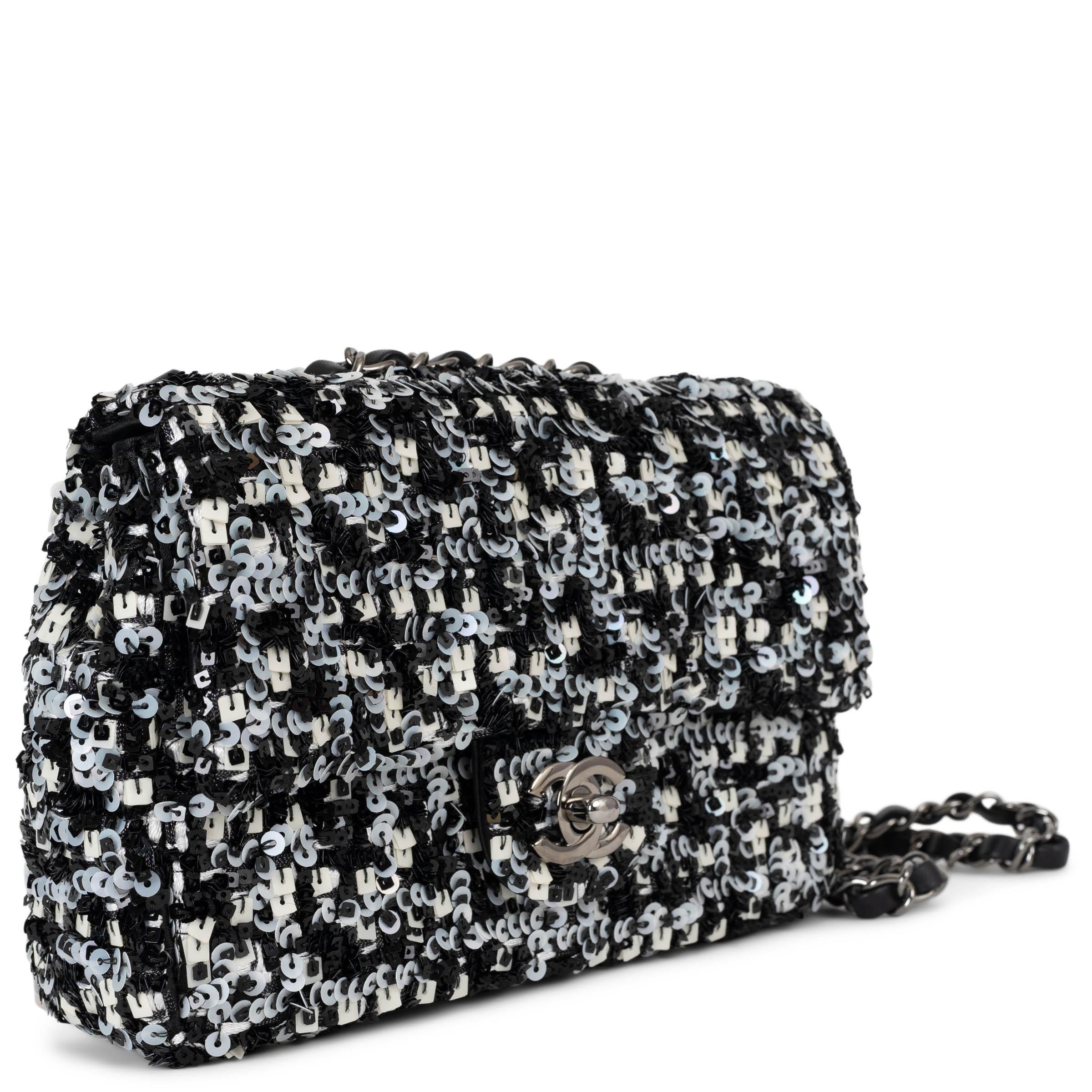 Ce sac à bandoulière Chanel Classic Mini Flap, 100% authentique, est une interprétation éblouissante de la silhouette emblématique, réalisée en paillettes rondes et carrées noires et blanches irisées qui scintillent à chaque mouvement. Doté de