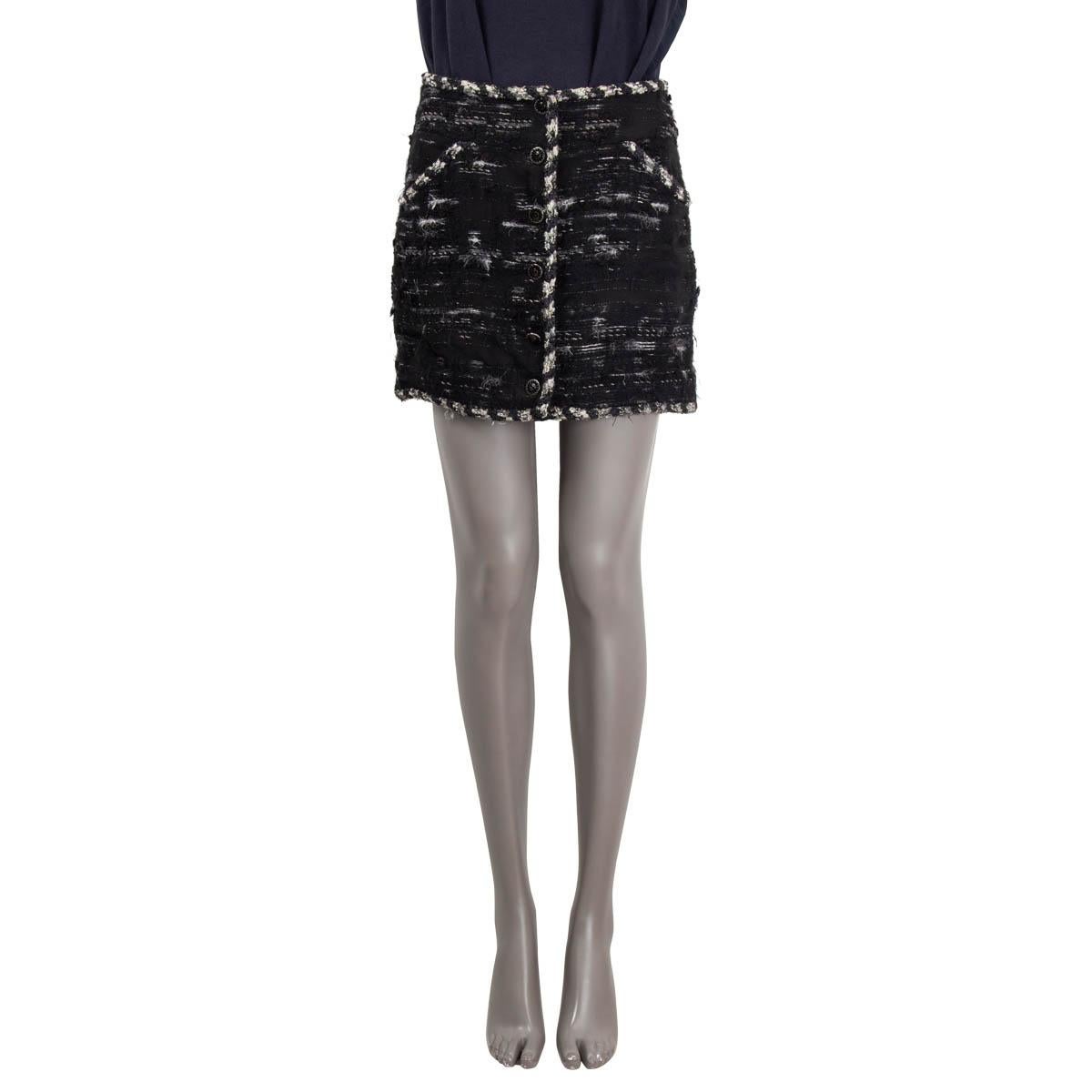 100% authentic Chanel  tweed mini skirt in black polyamide (22%), wool (20%), acrylic (19%), mohair (19%), silk (12%), polyester (3%), viscose (3%), cotton (1%) and rayon (1%). Features a braided trim, black enamel CC buttons and two slant pockets