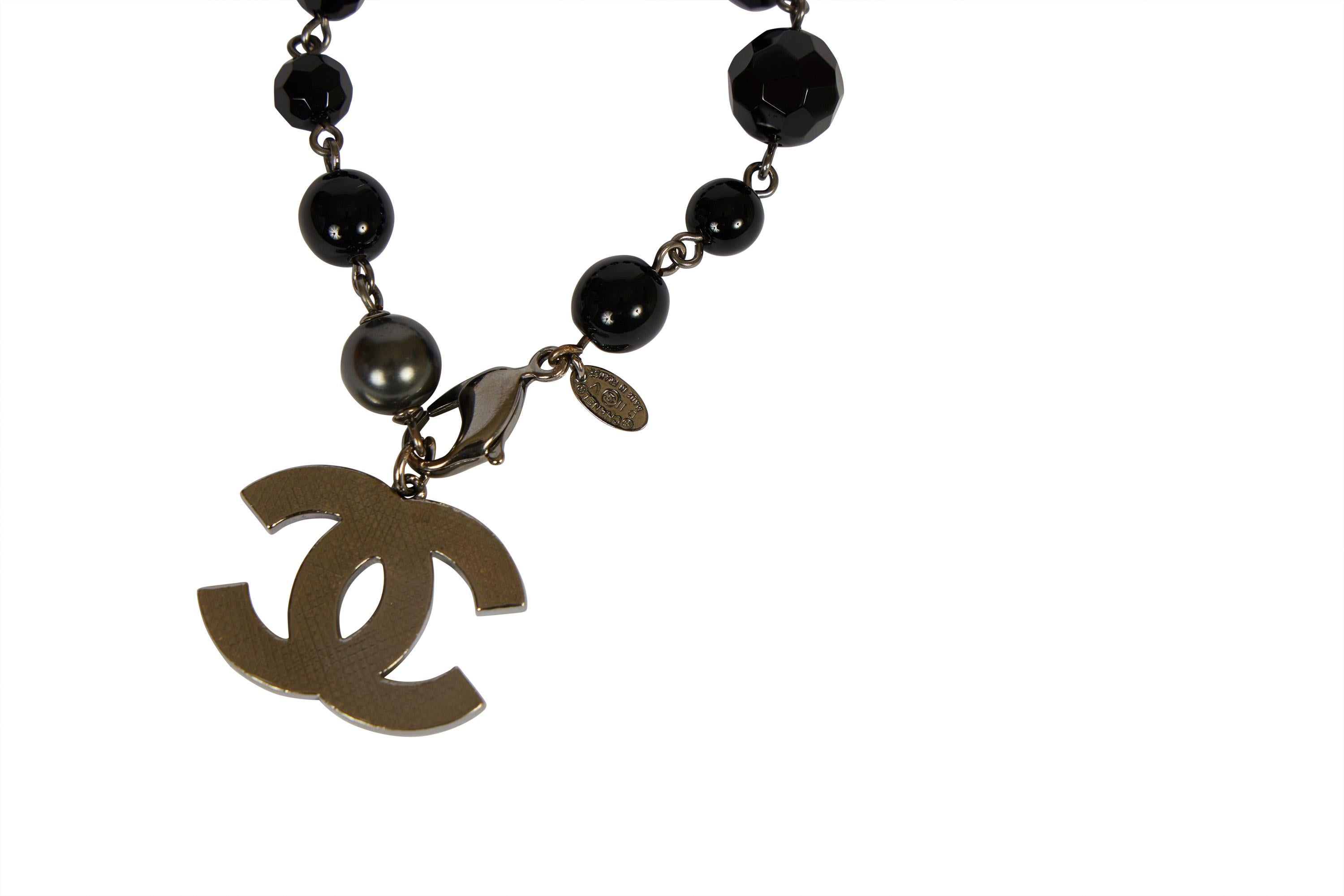 Bracelet Chanel en gripoix noir et chaîne en métal argenté avec breloque pendante cc. Collier assorti disponible dans une liste séparée. collection 2011, livré avec sa pochette ou sa boîte d'origine.