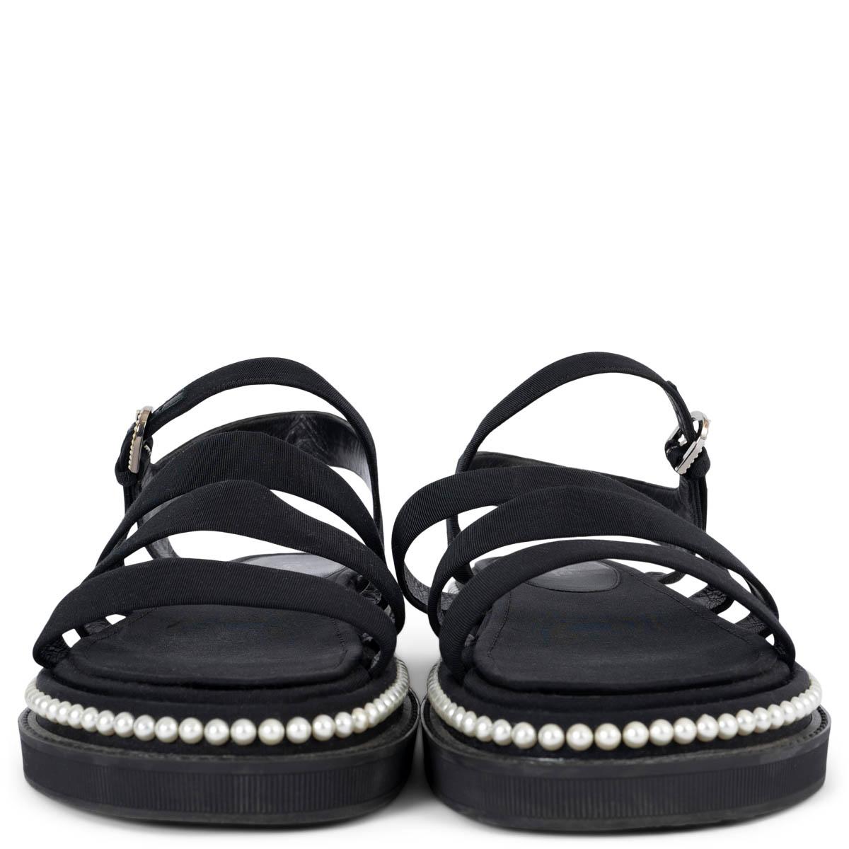 100% authentic Chanel 2017 REV pearl embellished flat sandals in black grosgrain. They feature grosgrain straps, ankle fastenings and the faux pearl embellishments. Have been worn and two tiny pearls are missing on the right shoe's CC logo on the