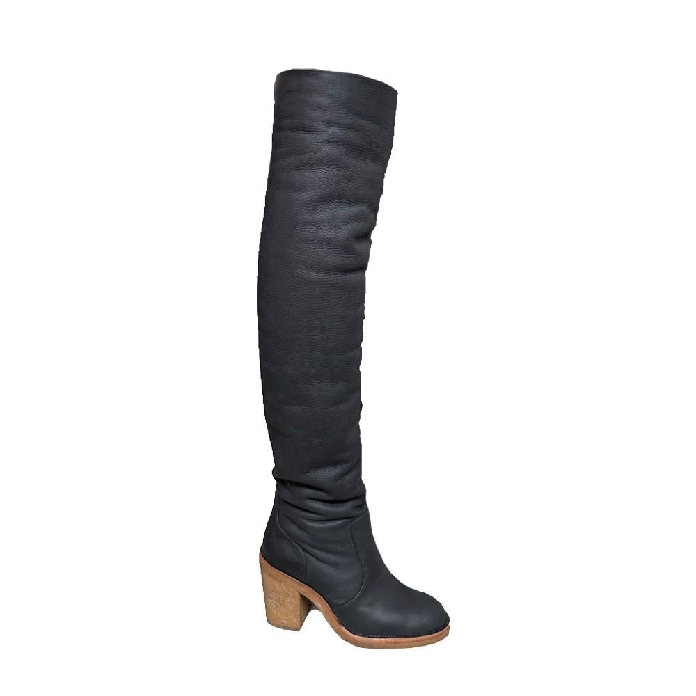 These Chanel black-heeled boots are expertly crafted from lambskin, making them robust yet supple against the winter cold. The over-the-knee length and shearling lining ensure a snug fit. These classic boots feature a round toe, pull-on design, and