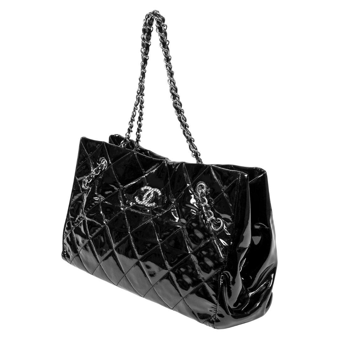 Crafted from black patent leather with silver hardware, this tote features a magnetic snap closure. The canvas interior offers one zippered pocket alongside two slip pockets.

SPECIFICS
Length: 14.6
Width: 6
Height: 9.5
Strap drop: 11
Authenticity