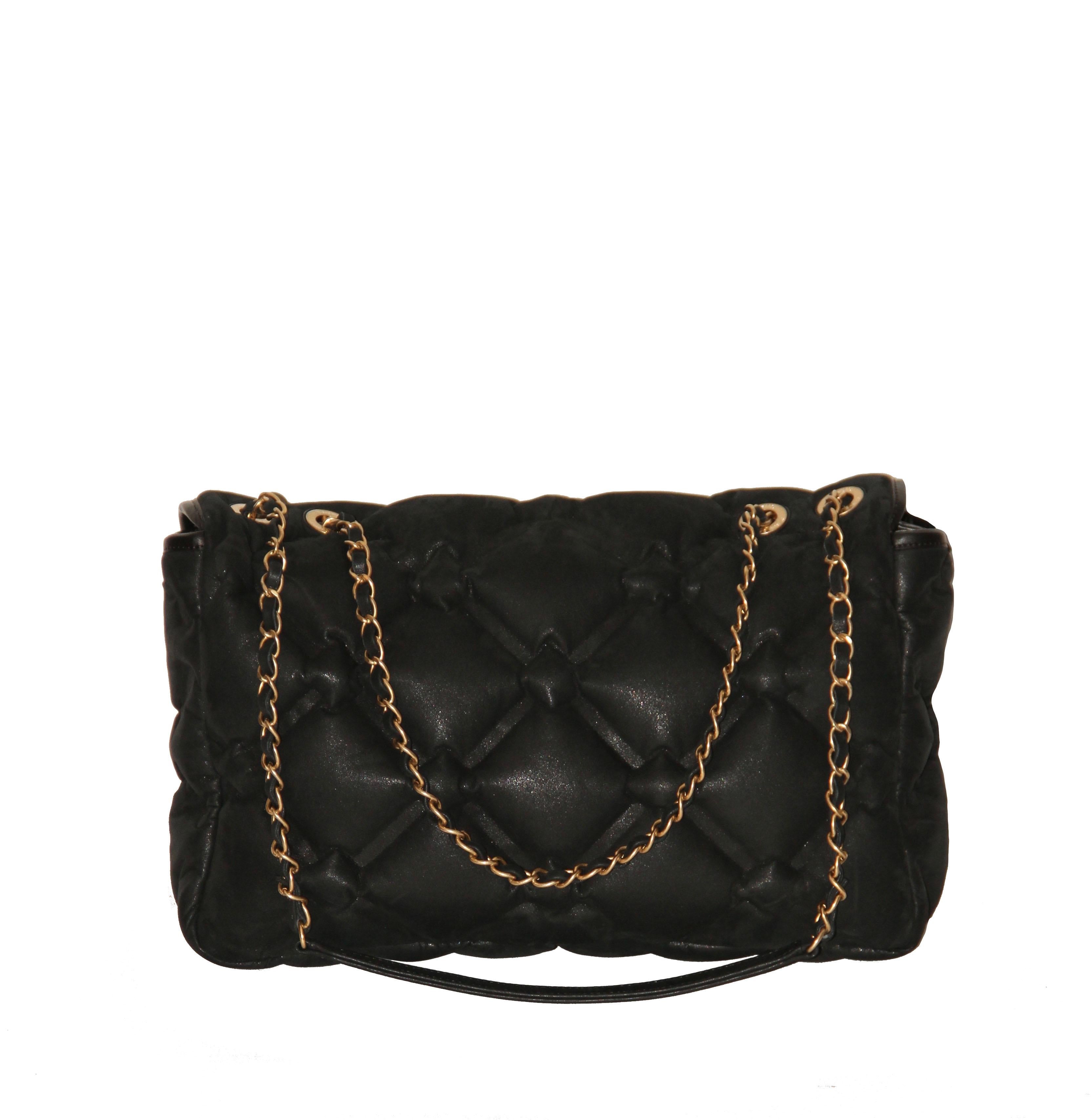 This Jumbo flap bag is crafted from black iridescent leather in chesterfield-style quilting.
The flap has a black leather trim and opens to a padded nylon lined interior. 
The bag has dual chain and leather interwoven straps. 
Its CC lock closure