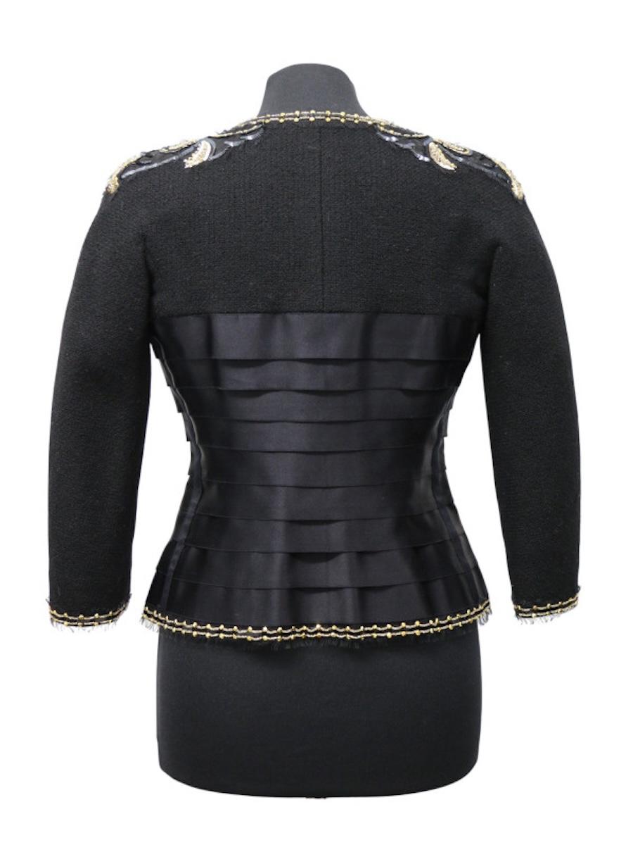 Preciosa chaqueta corta bordada Chanel Lesage.
Mangas 3/4. Bordado Lesage en los hombros y ribete compuesto de lentejuelas negras, doradas y blancas y strass dorado. La chaqueta está hecha de dos materiales, tweed negro y satén de seda.
Estado: muy