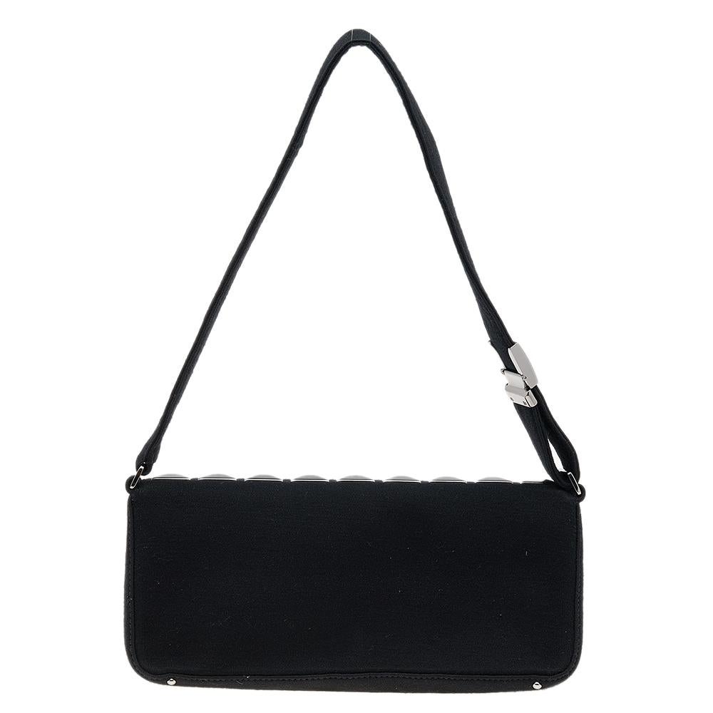 This Pyramid Stud Flap bag from the House of Chanel is a beauty to behold! It is made from black jersey on the exterior and flaunts studded embellishments on the front. It has gunmetal-tone hardware, a fabric-lined interior, and a sturdy handle.