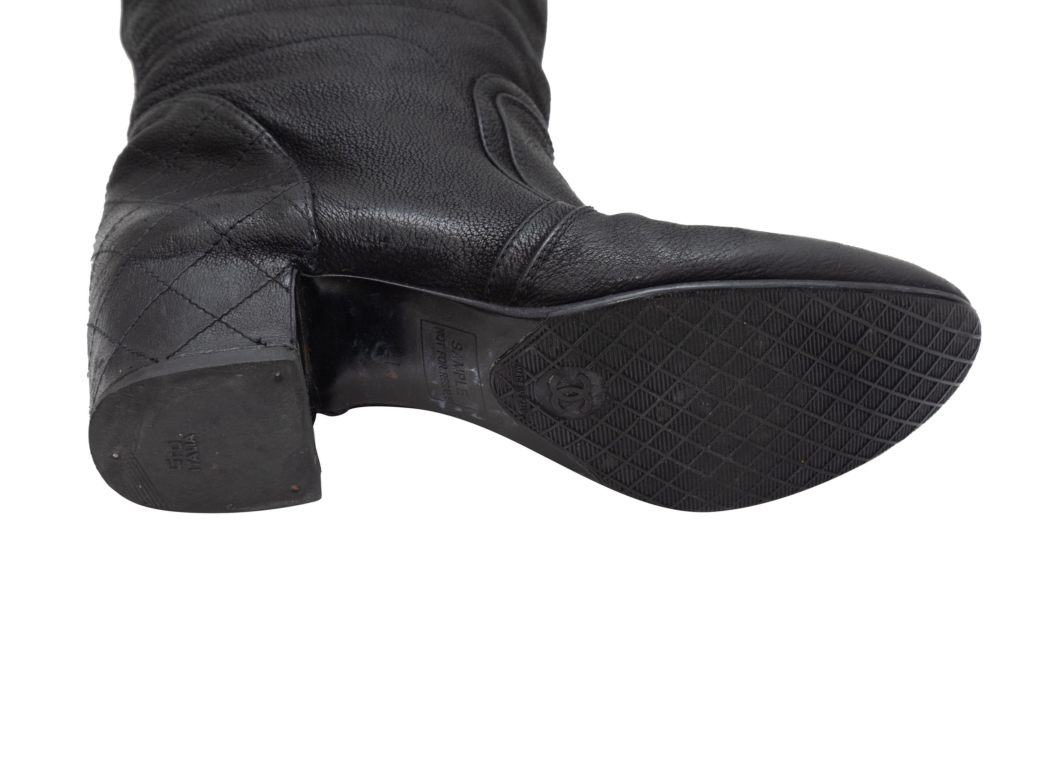 Product Details: Black leather knee-high boots by Chanel. Block heels. Zip closures at counters. 1.75