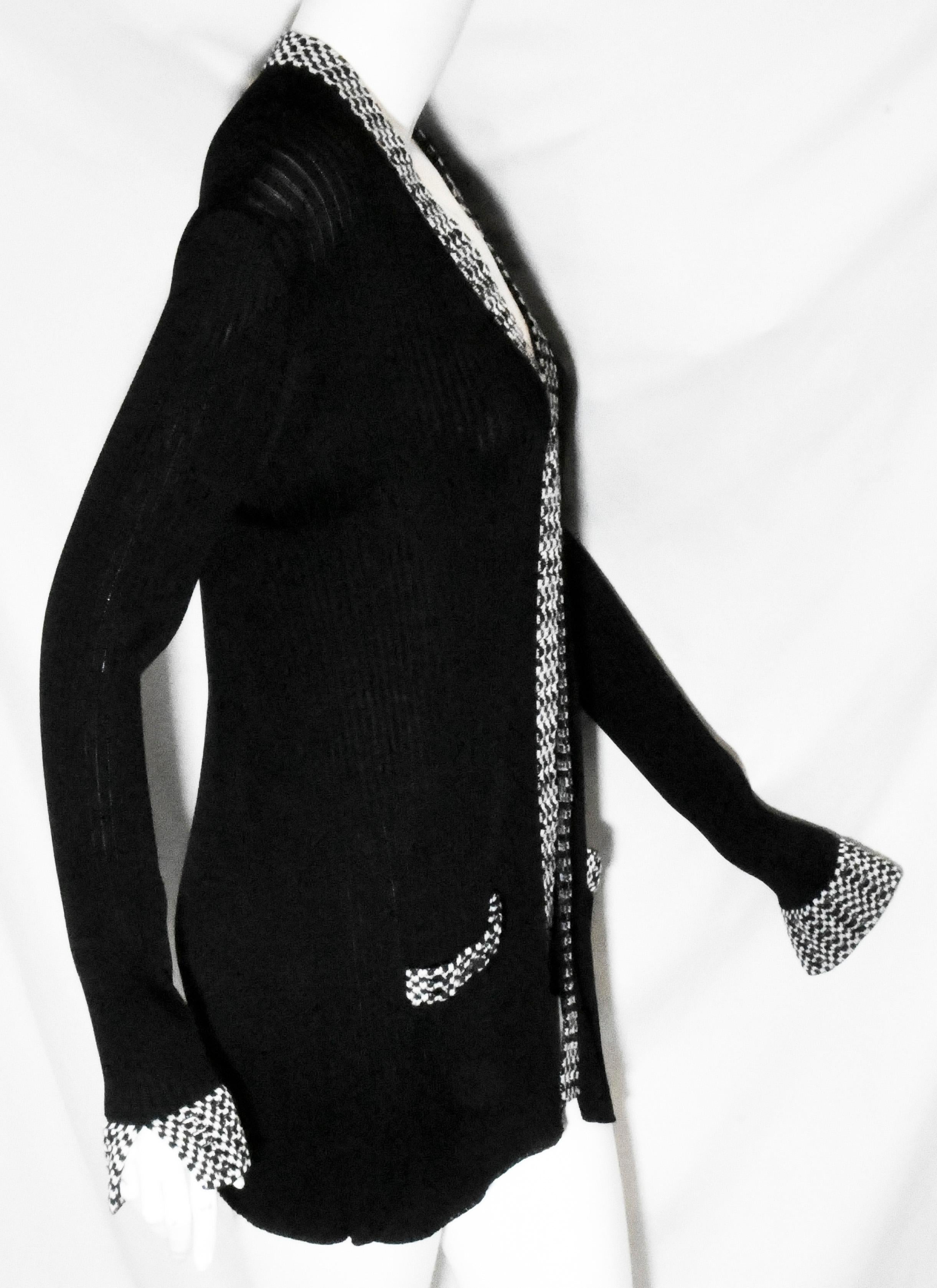 Chanel black knit open front jacket gives this beautifully textured knit jacket an easy, casual feel.  This jacket is trimmed with black and white crocheted design around the neckline, front of jacket, on the 2 patch pockets at front and, also, on