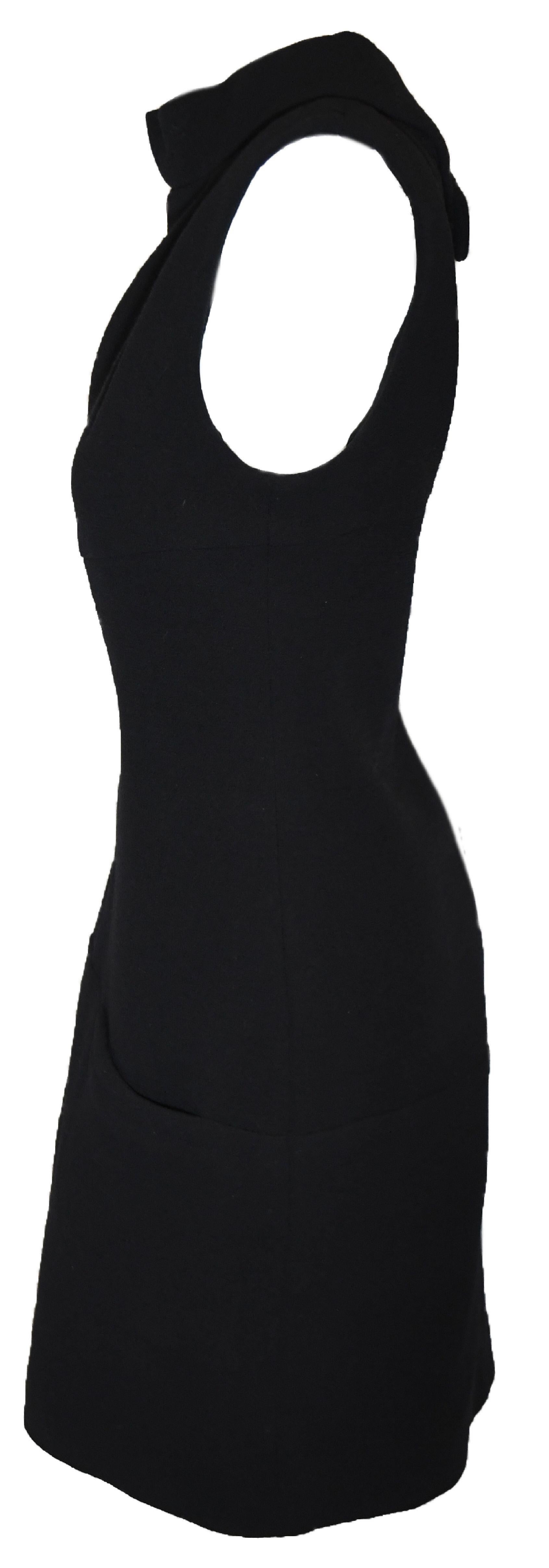 Chanel black wool knit dress with cowl collar at front and a peek a boo opening at the back.   This dress is the epitome of Chanel, a sophisticated and classic dress.  At the back, for closure a zipper and a beaded Chanel button.  This dress is