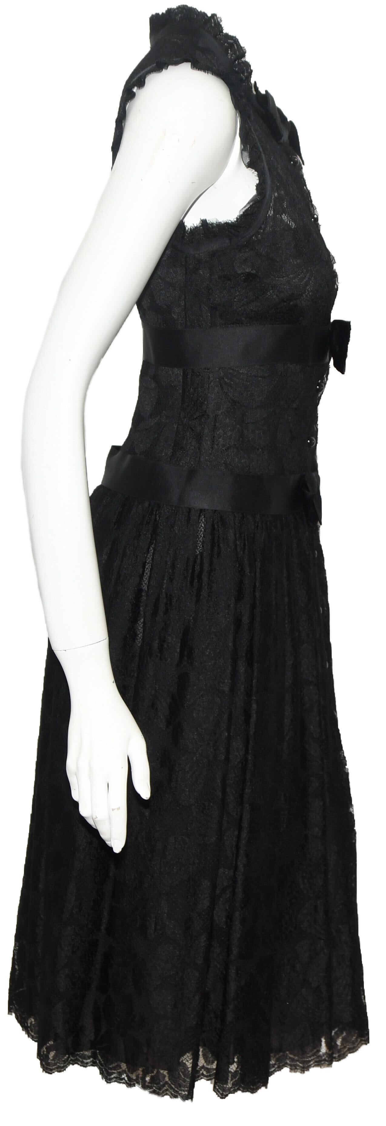 Chanel black lace evening midi dress is a classic but yet so contemporary!   This 2005 Fall collection dress has an up collar that contains gathered lace and satin ribbon tied at the neck with in a bow.  Two more satin bows are tied just below the