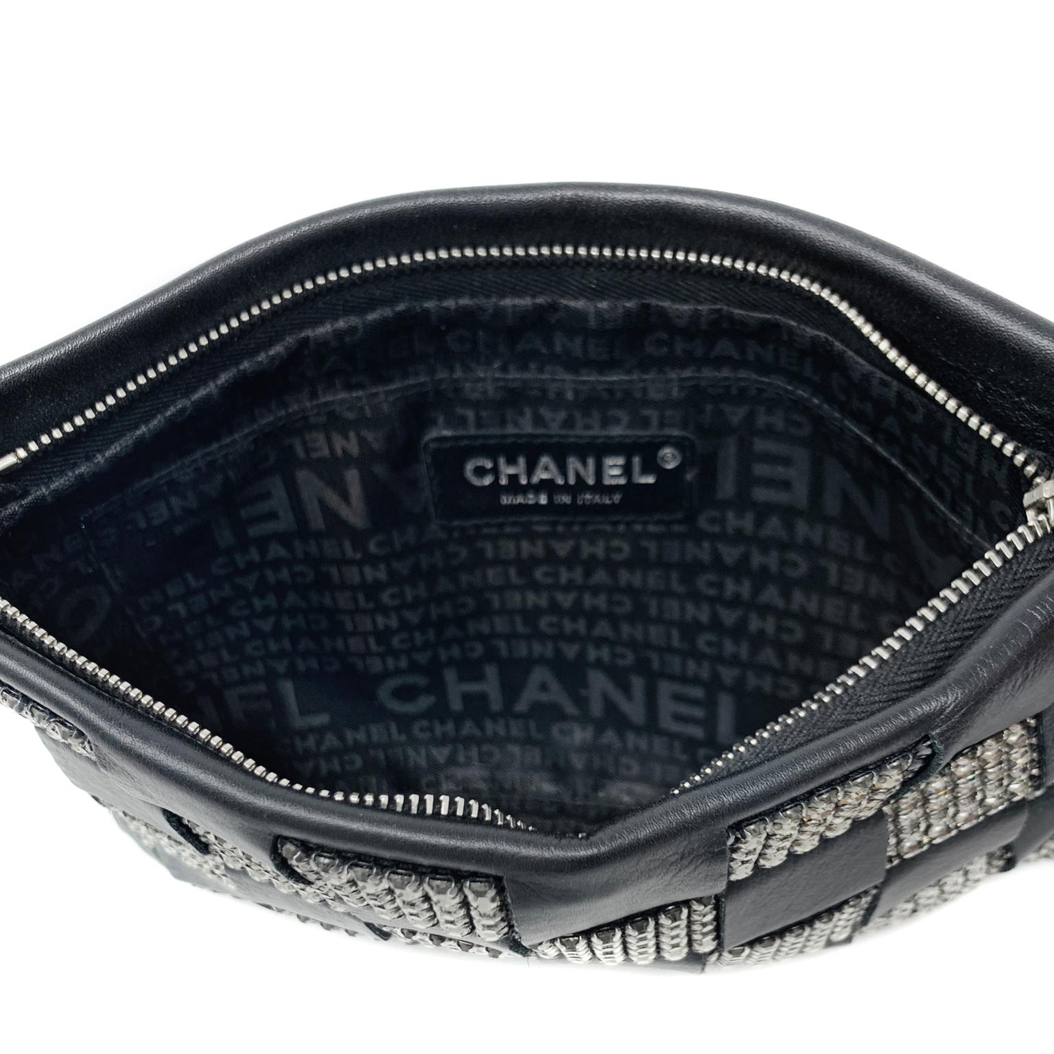 This authentic Chanel Black Lambskin and Crystal Wristlet is in pristine condition.  Perfectly sized for an evening’s essentials, this pouch goes with everything.
Black lambskin is woven in a checkered pattern with Swarovski crystals.  Zippered top