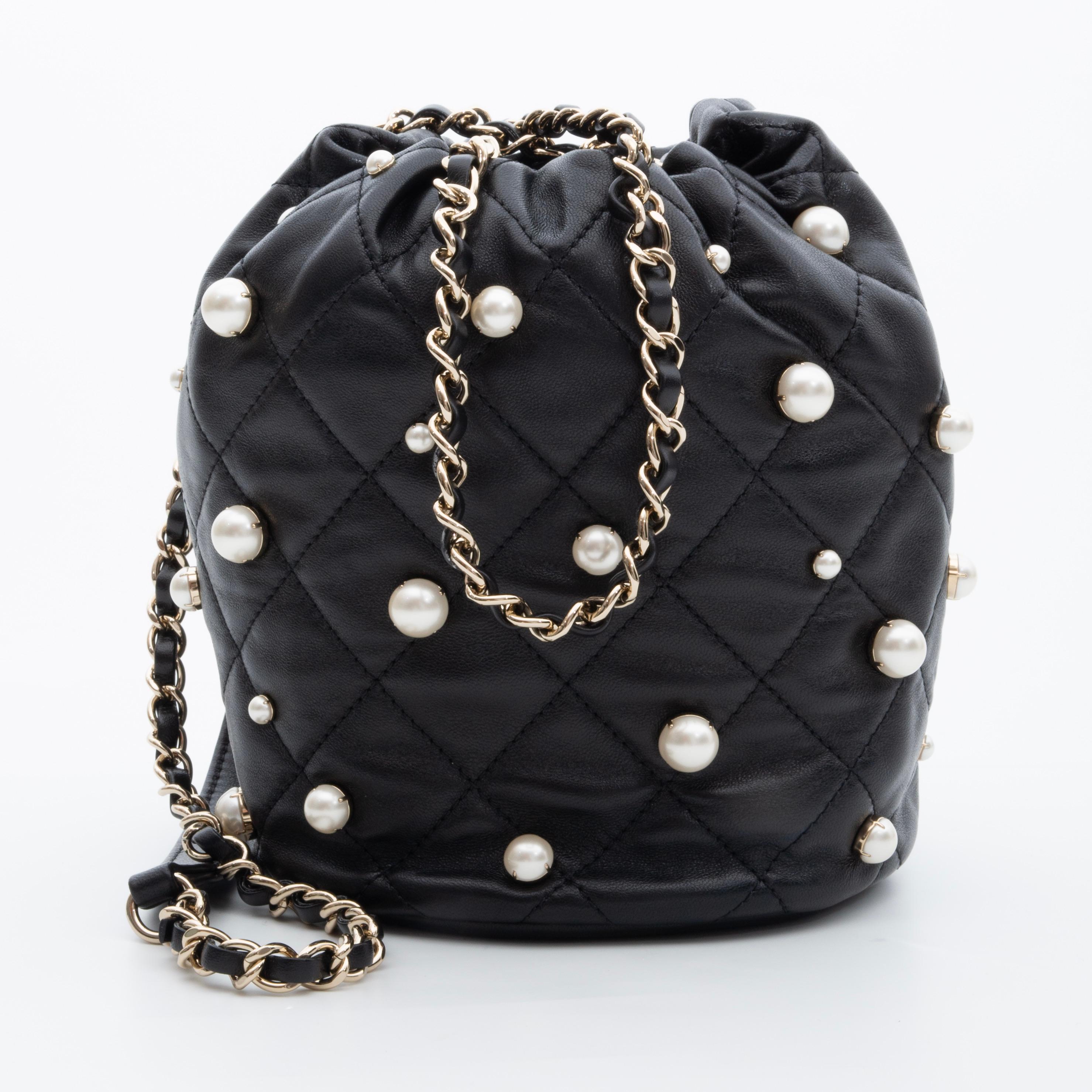 From the Spring/Summer 2021 collection. This limited Edition Chanel bag is made with lambskin leather with diamond quilting in black. The bag features pearl embellishments, a chain interlaced with leather drawstring pull, metallic CC logo fastener