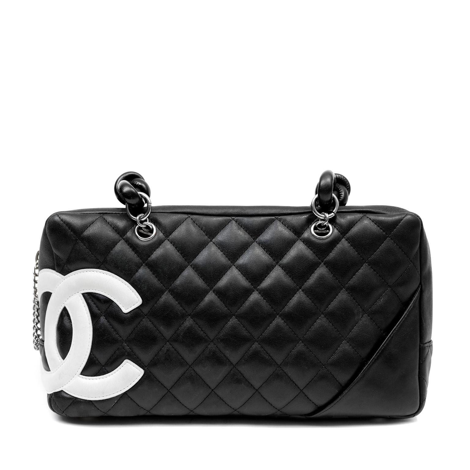 This authentic Chanel Black Lambskin Cambon Ligne Bowler Bag is a fantastic find in excellent condition. Sturdily constructed black bowler is quilted in signature Chanel diamond pattern.  Large white interlocking CC is stitched off center along one
