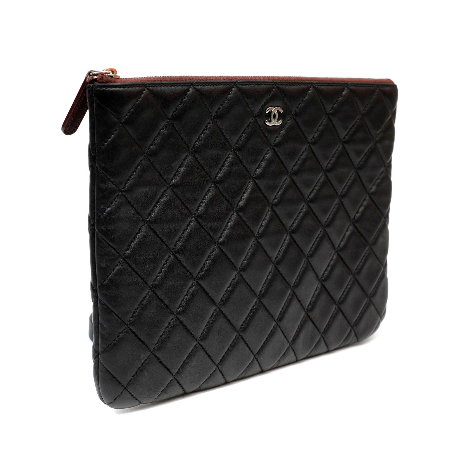 This authentic Chanel Black Lambskin Classic Case is in pristine condition.  Spacious slim zip top case is quilted in signature Chanel diamond pattern. Perfect for evening clutch carry or tossing inside a larger bag.  Dust bag