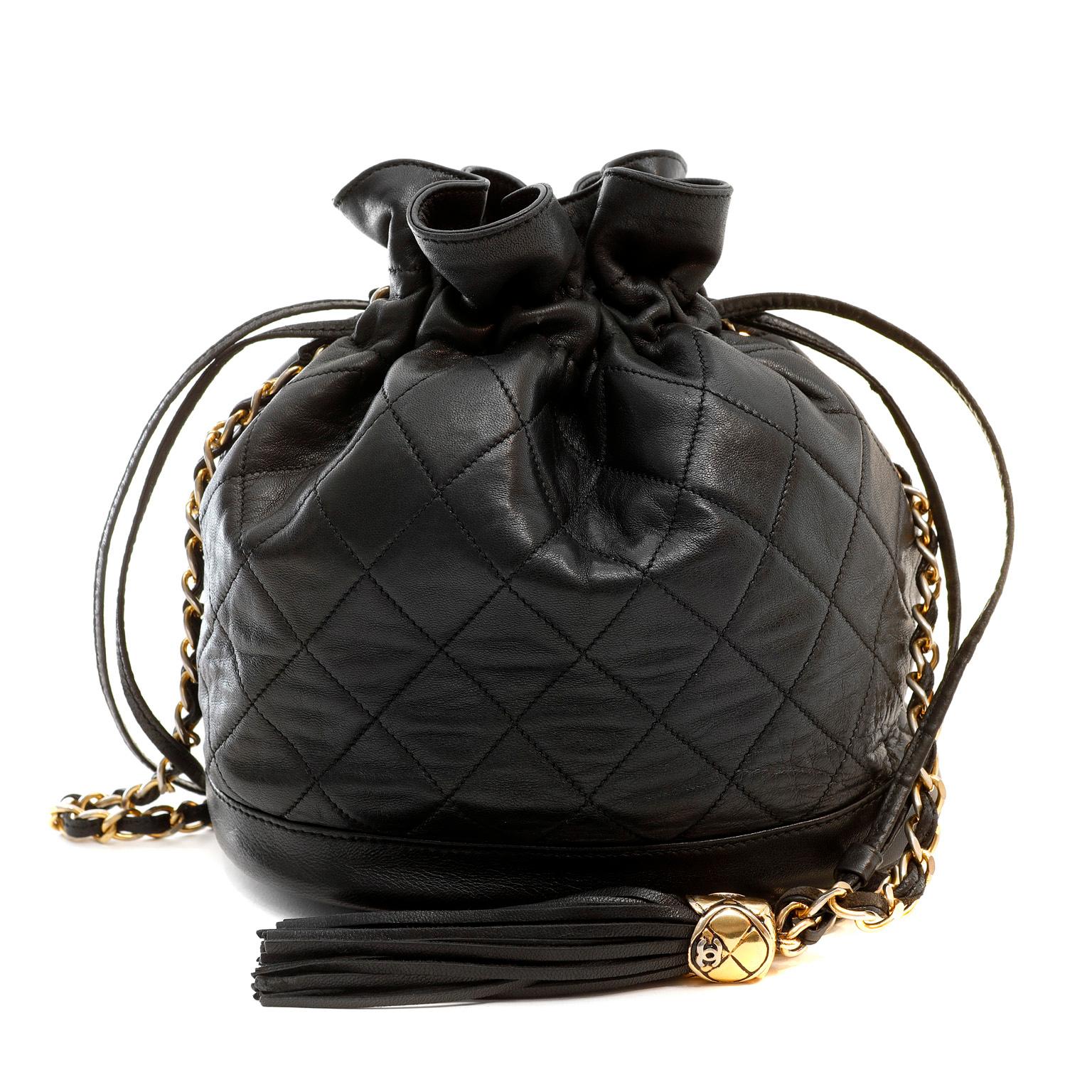 This authentic Chanel Black Lambskin Drawstring Crossbody Bag is in good previously owned condition. Supple black lambskin is quilted in signature Chanel diamond pattern.  Sac shape with leather drawstring closure.  Single leather and gold chain