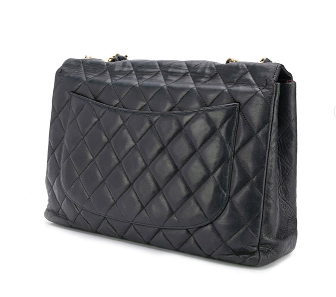 1980s black lambskin Chanel Jumbo bag featuring a chain and leather strap (total length 48,4 in. (123cm)), a foldover top with twist-lock closure, a main internal compartment, an internal slip pocket, an internal zipped pocket, an internal logo