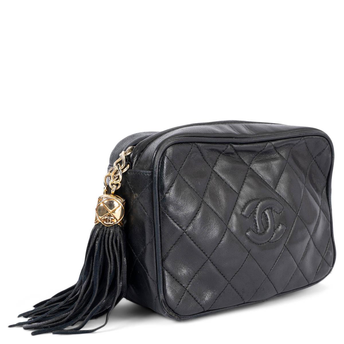 100% authentic Chanel quilted front logo tassel camera shoulder bag in black smooth lambskin featuring gold-tone hardware. Opens with a tassel zipper on top and is lined in black leather with one zipper pocket against the back. Has been carried and