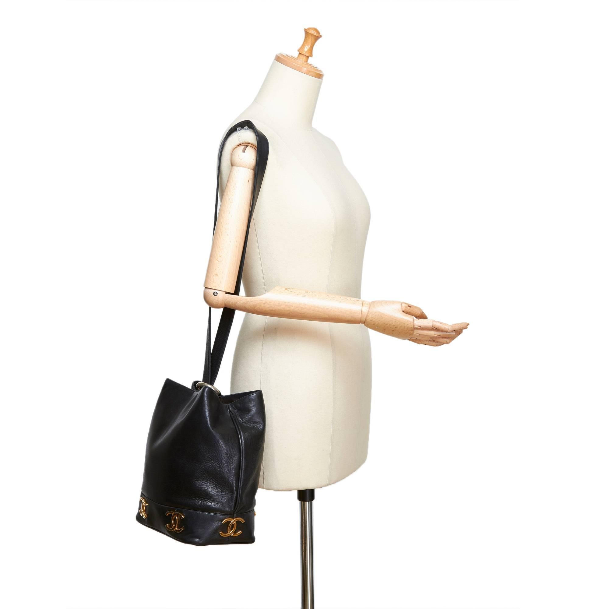 - Vintage 90s Chanel black lambskin leather bucket bag.   

- Featuring single strap with a gold-toned 