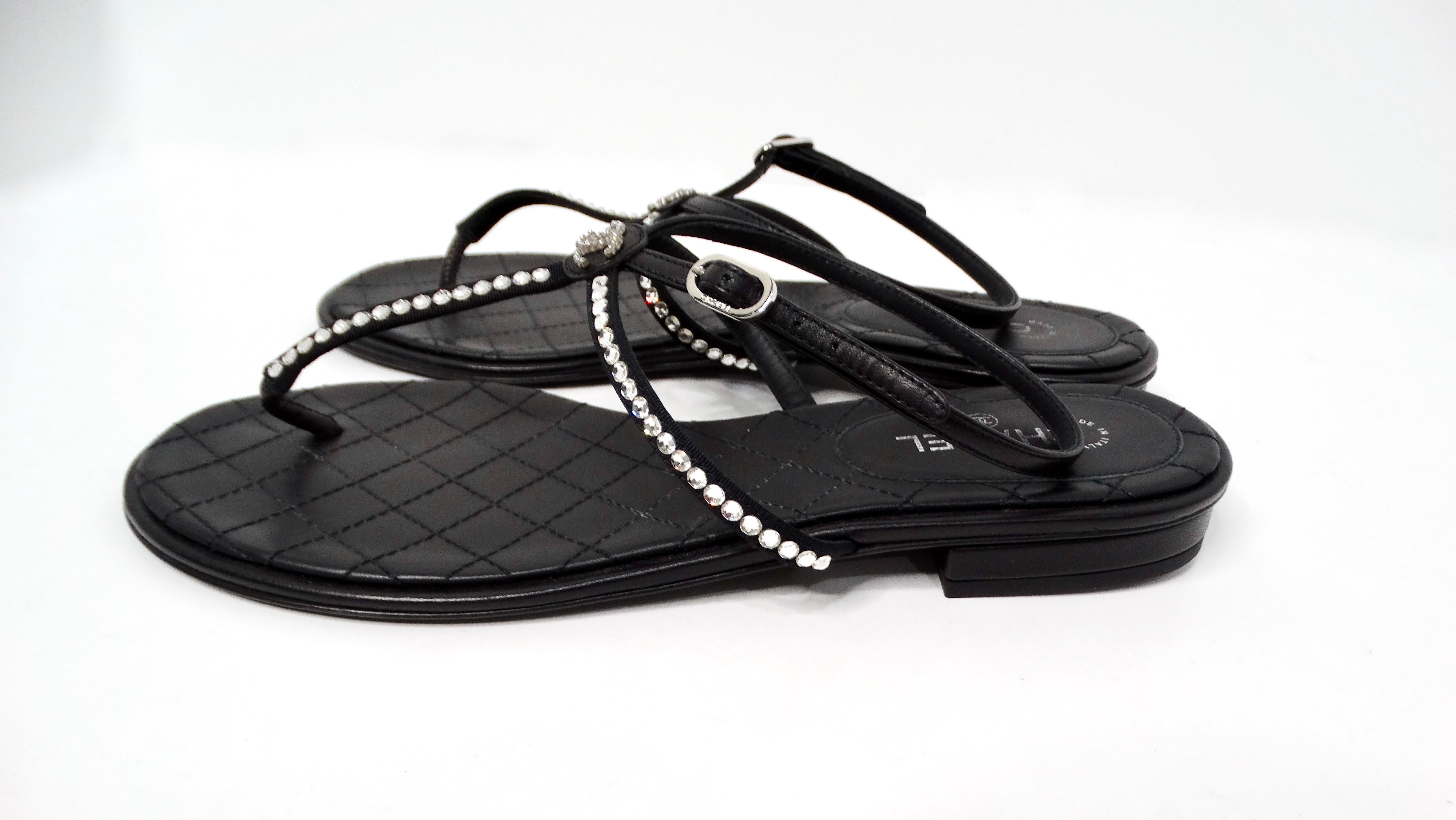 Step into luxury with the Chanel Black Lambskin Leather Interlocking CC Rhinestone Thong Sandals, a sophisticated addition to any discerning fashionista’s collection. These elegant sandals feature a small, interlocking crystal CC logo at the center