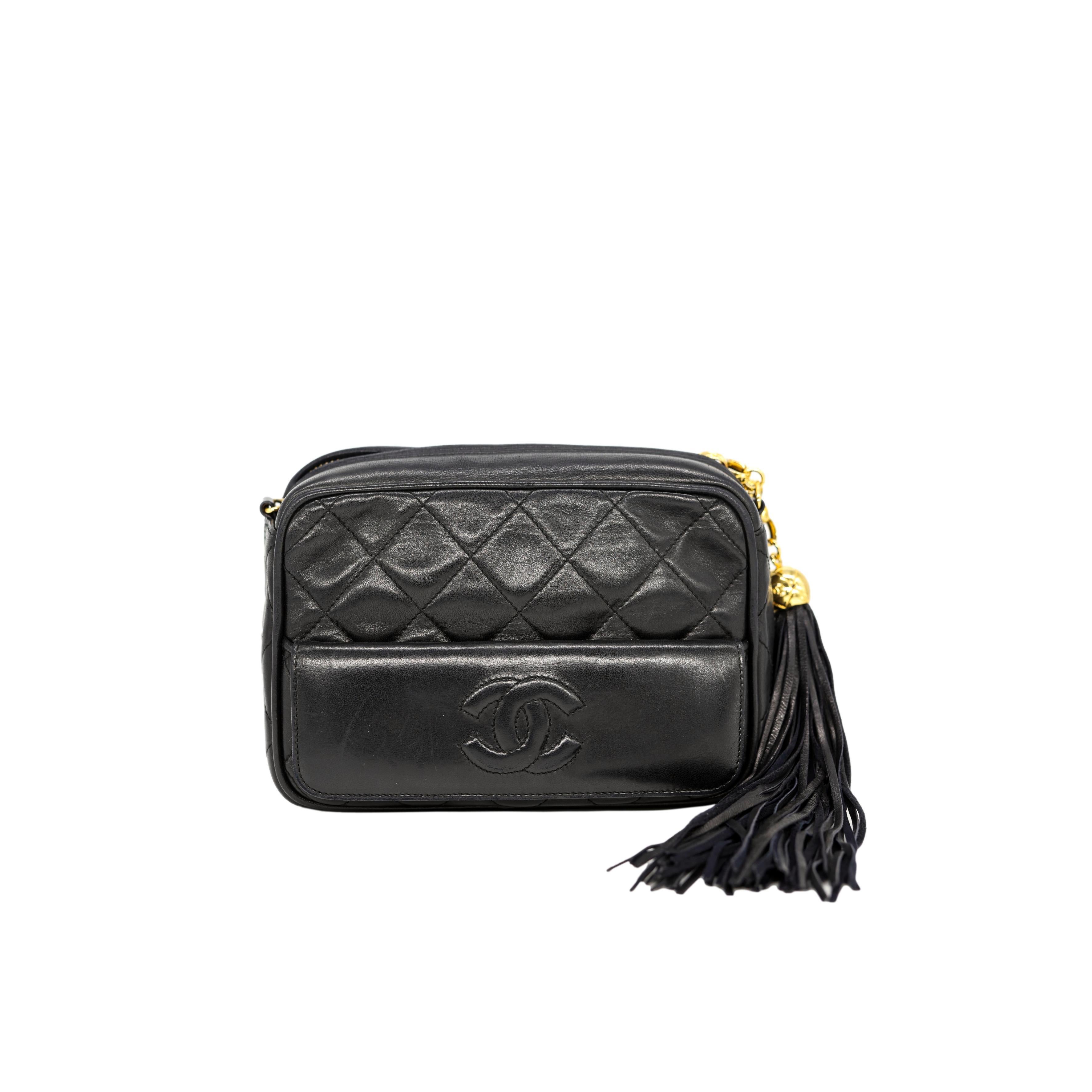 Chanel Black Lambskin Mini Tassel Camera Bag with 24KT Hardware, 1989 - 1991. This extremely rare and highly sought after piece of Chanel history was one of the very first camera bags produced, baring a serial code of 