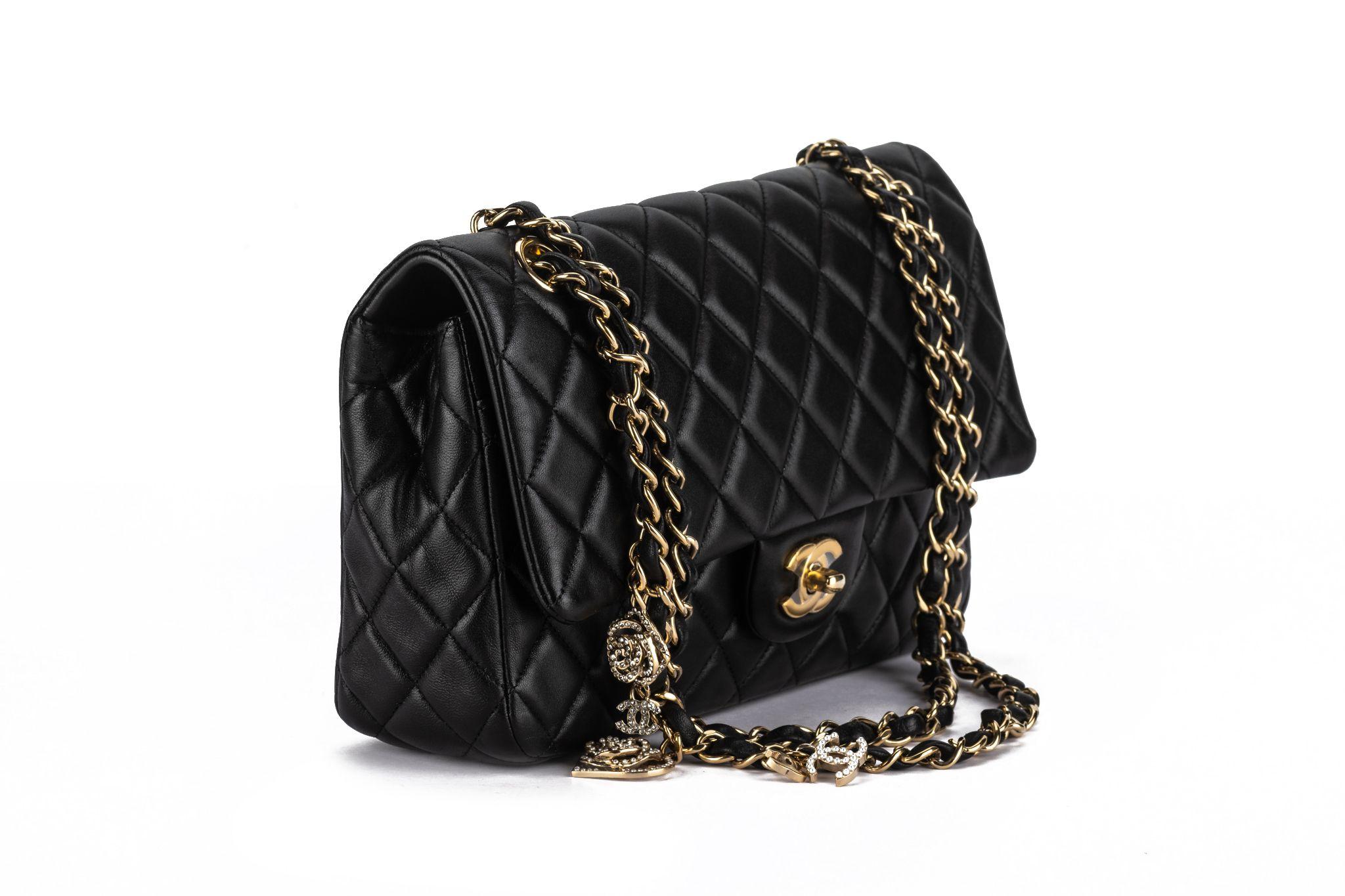 Ce mini sac à rabat rectangulaire en cuir d'agneau noir matelassé Valentine Charms de Chanel est une pièce spéciale fabriquée à partir du cuir d'agneau le plus fin. Des accessoires en pierre dorée et des charmes Chanel embellissent la sangle