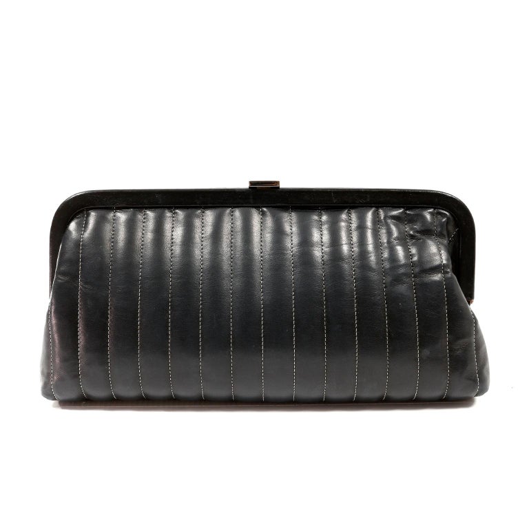 This authentic Chanel Black Lambskin Vertical Stitch Clutch is in excellent condition.  Elegant and timeless, this perfectly sized clutch is a great investment piece for a classic wardrobe.  
Soft black lambskin framed clutch is vertically stitched