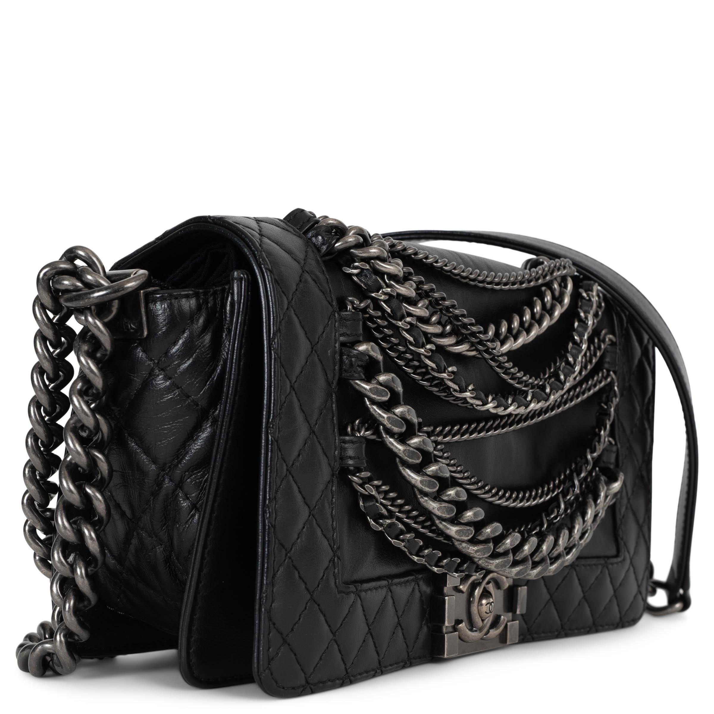 Este bolso Chanel Enchained (antiguo) mediano 100% auténtico, de suave piel negra, es una versión atrevida y atrevida del icónico Boy Bag. Con intrincados detalles de eslabones de cadena, el característico cierre Boy de presión y el clásico