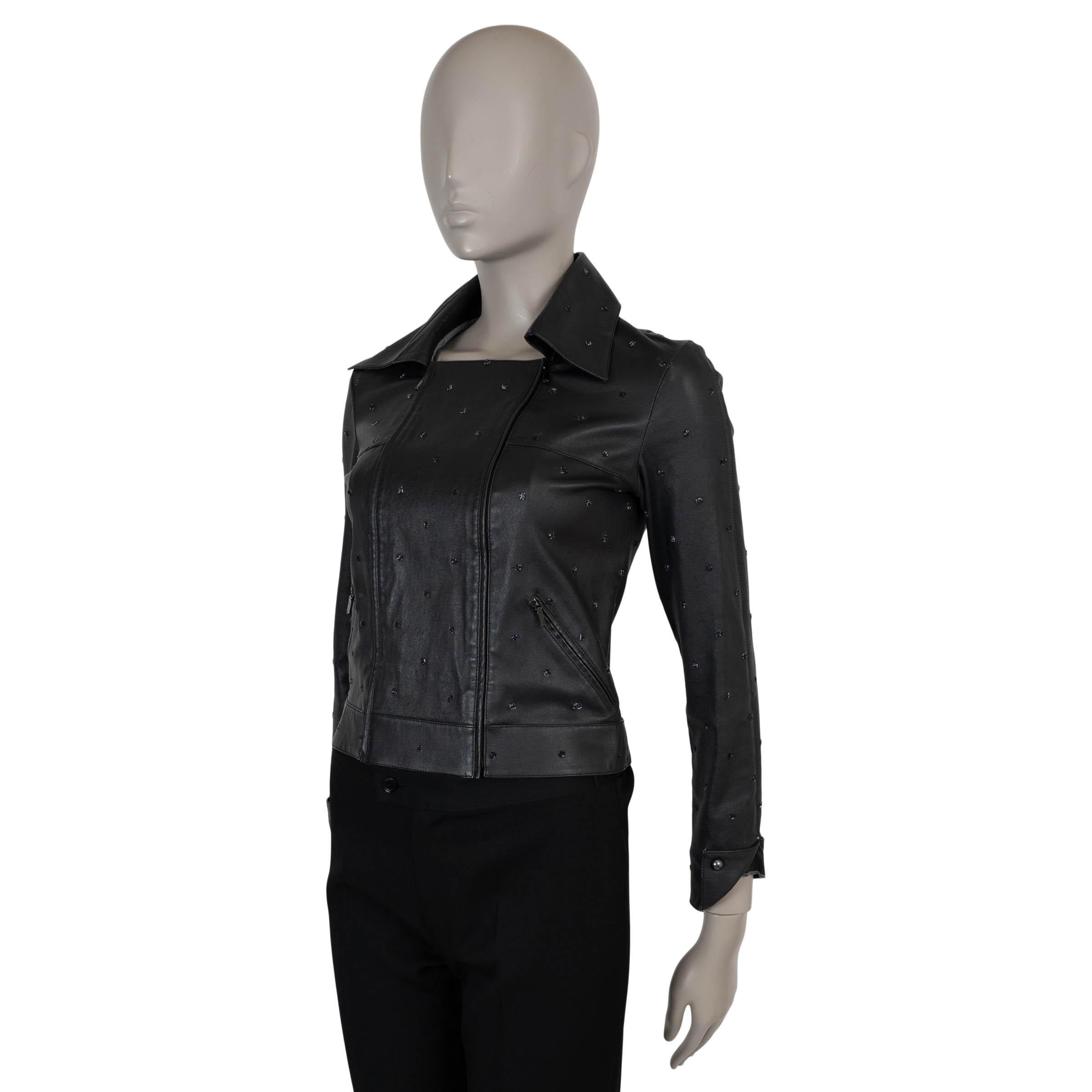 Diese 100% authentische Chanel Bikerjacke aus schwarzem Lammleder (50%), Baumwolle (49%) und Elastan (1%) ist mit aufgestickten Polka-Dots verziert. Die taillierte, verkürzte Silhouette, die doppelte Reißverschlussfront, der spitze Kragen und die