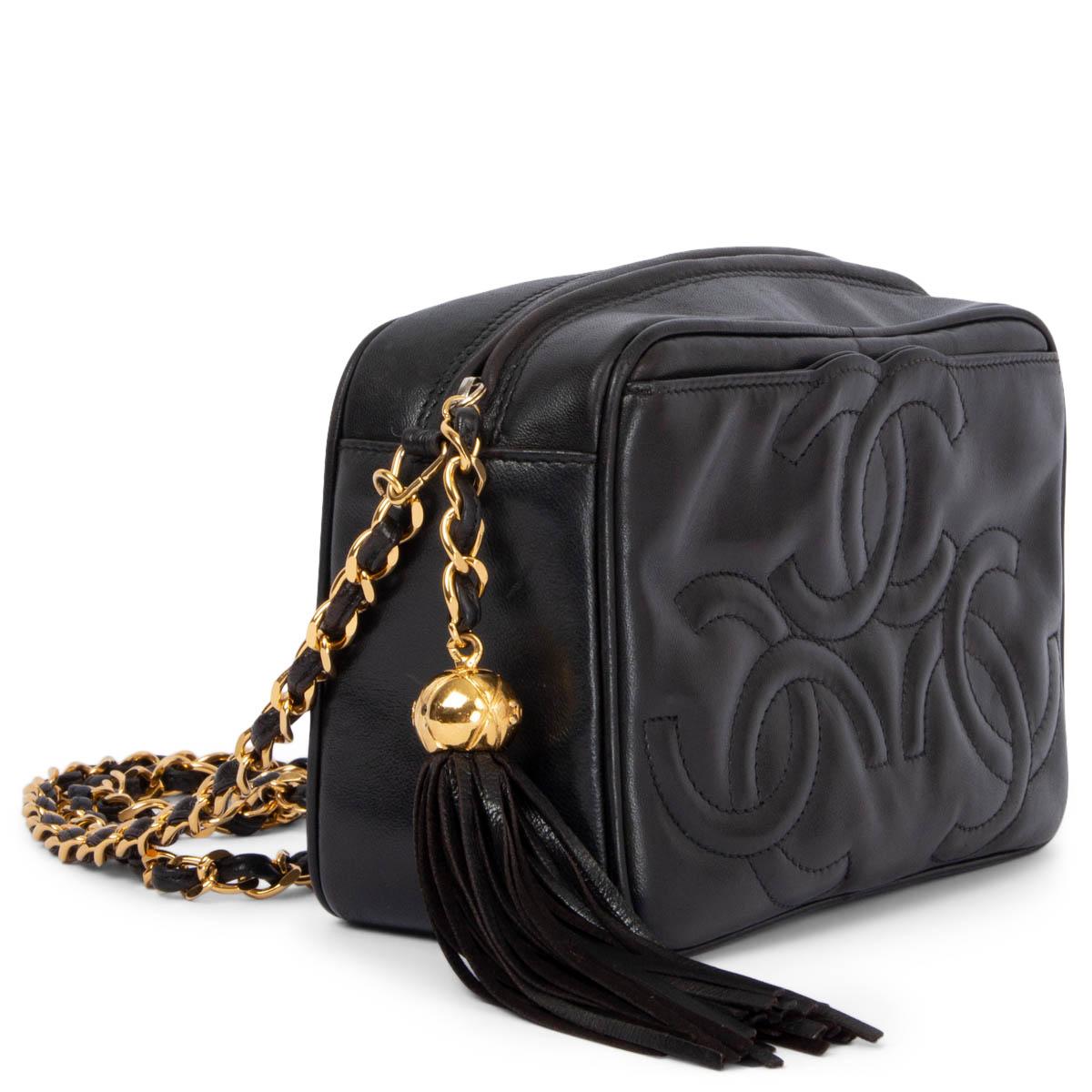 100% authentic Chanel 1994 triple logo tassel camera shoulder bag in black smooth lambskin featuring gold-tone hardware. Open with a tassel zipper on top and is lined in black leather with one ziper pocket against the back and a flat pocket against