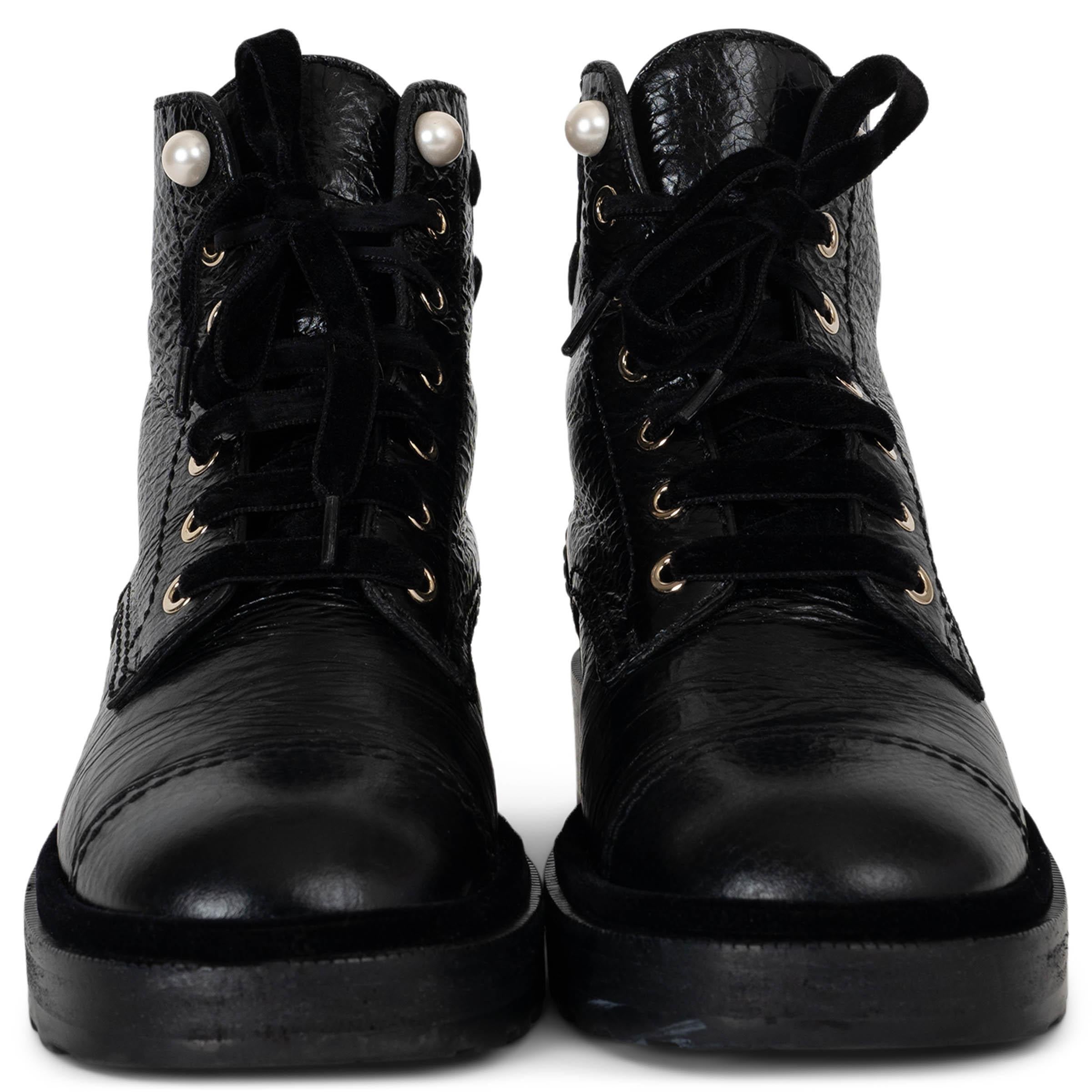 This 100% authentic Chanel short combat boots in black shiny grained calfskin leather combine edgy style with feminine detailing. Embellished with velvet CC patches and faux pearl buttons, these boots are a statement piece. They feature round toes,