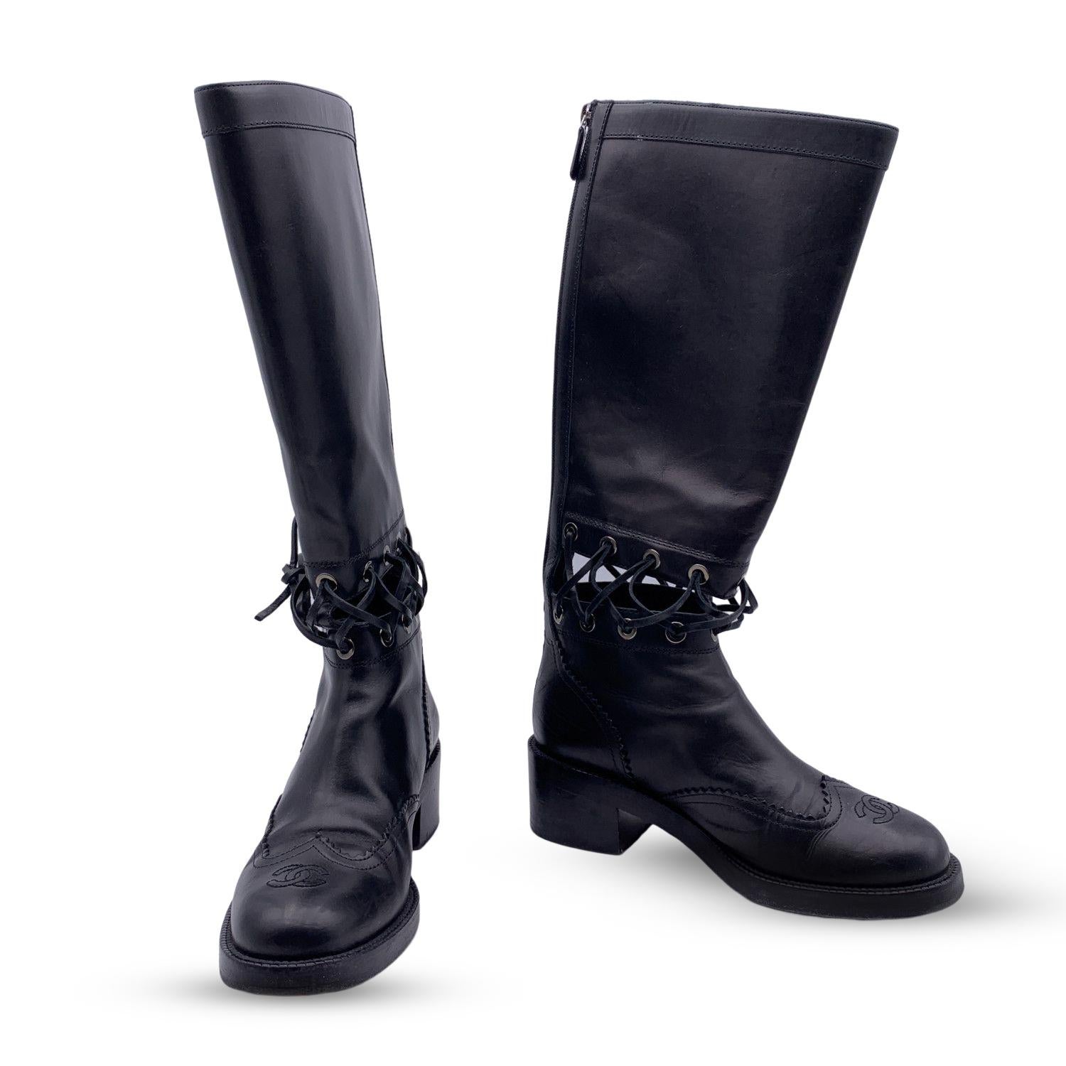 Chanel black leather Lace-Up Cutout Knee-High Boots. Crafted in black leather with cut out details. They feature round toe, CC - logo on toes rear zip closure. Low heels Leather sole. Heels Height: 2 inches - 5.1 cm. Calf circumference: 13.75 inches