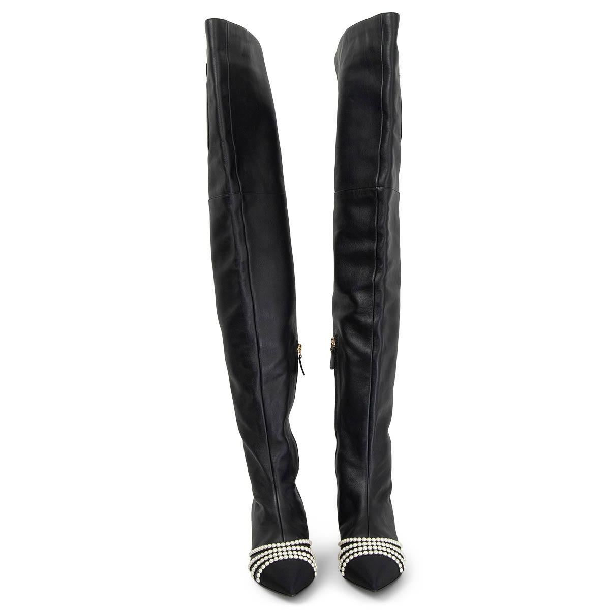 100% authentic Chanel 2016 Rome Over-Knee Boots in black smooth leather embellished with faux pearls, a grosgrain tip and a patent leather logo embellished block-heel. They come with a thigh pocket with a pearl push-button. Have been worn and are in