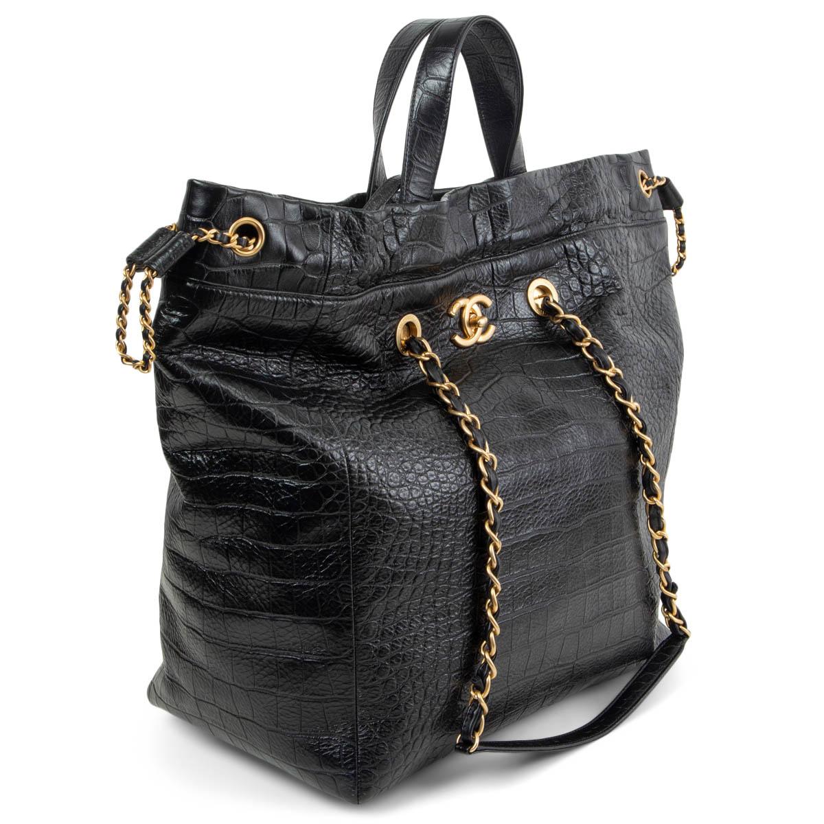 100% authentic Chanel Large Shopping Tote in black croco embossed calfskin with gold-tone hardware. The bag features an interlocking CC turn lock, chain link shoulder straps threaded with leather and leather top handles. The cinch cord opening at