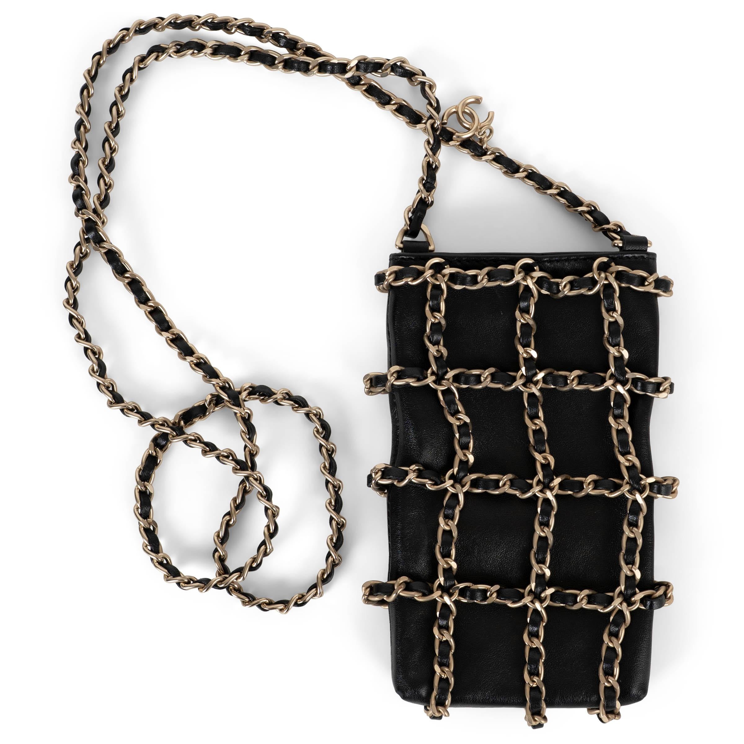 Diese 100% authentische Chanel Tech Me Out Handytasche ist aus schwarzem Lammleder gefertigt und in einem Käfig-Effekt mit ineinander verwobenen goldfarbenen Metallketten gestaltet. Die schlanke Silhouette der Tasche ist perfekt, um das Wesentliche