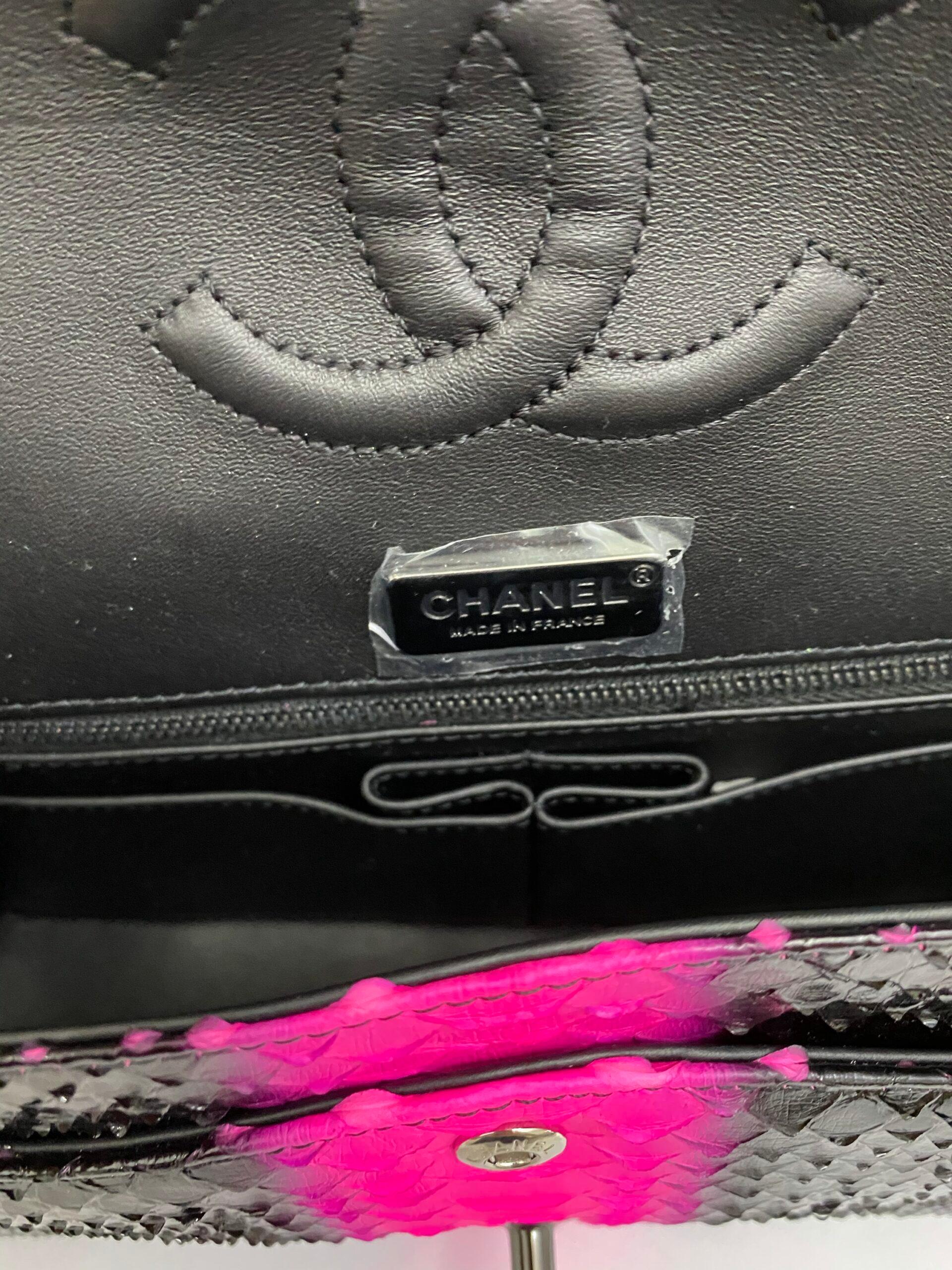 Chanel bag signed 2.55 double-flap model in limited edition. Made of black python leather with fuchsia central stripe and black hardware.
The product is equipped with an interlocking closure with classic CC logo, internally lined in black leather,