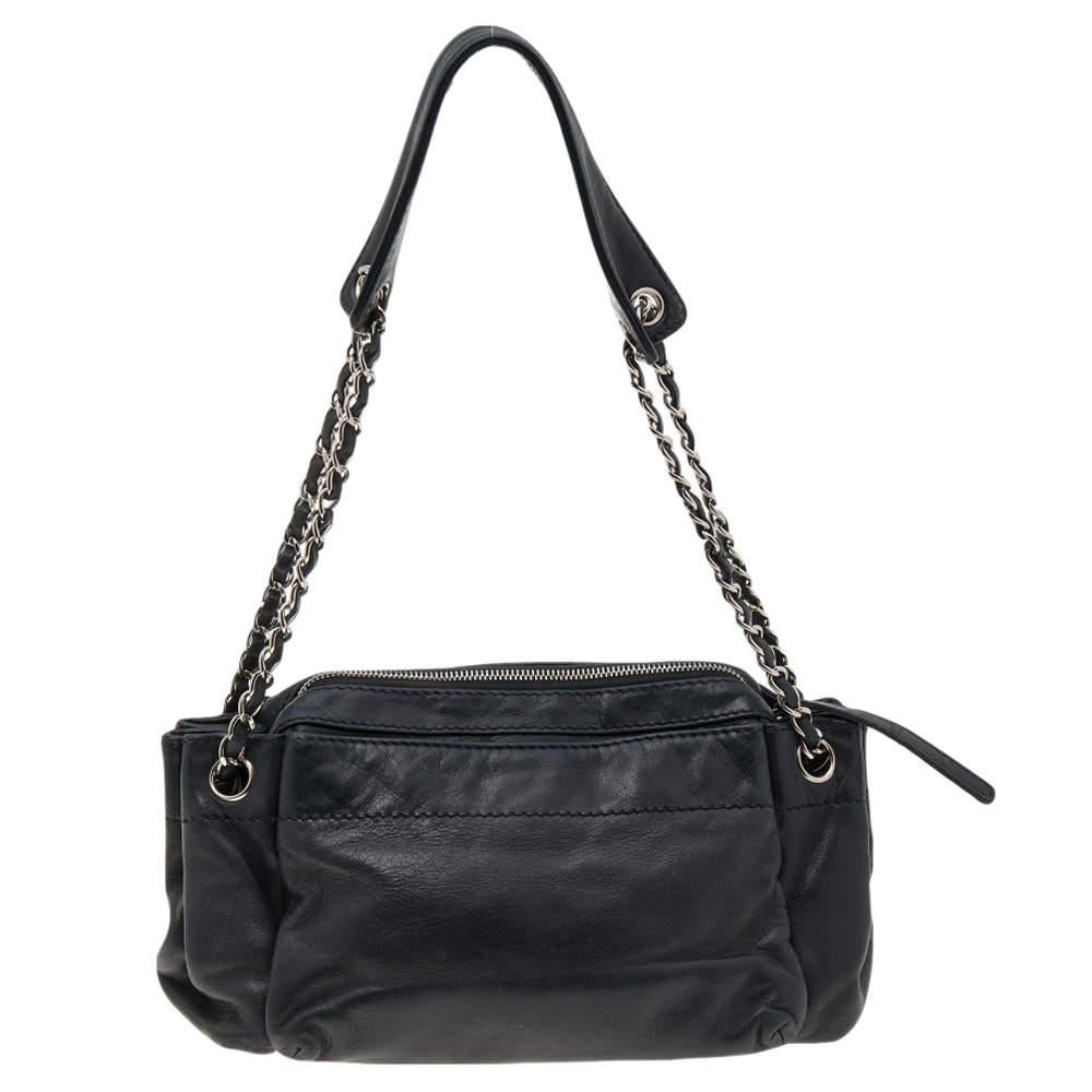 Connu pour sa grande qualité et sa finition brillante, ce sac à main de Chanel vous accompagnera pendant des années. Labellisé en cuir noir, il porte le logo de la marque sur le devant. Le sac est suspendu à de fines lanières de chaîne.

