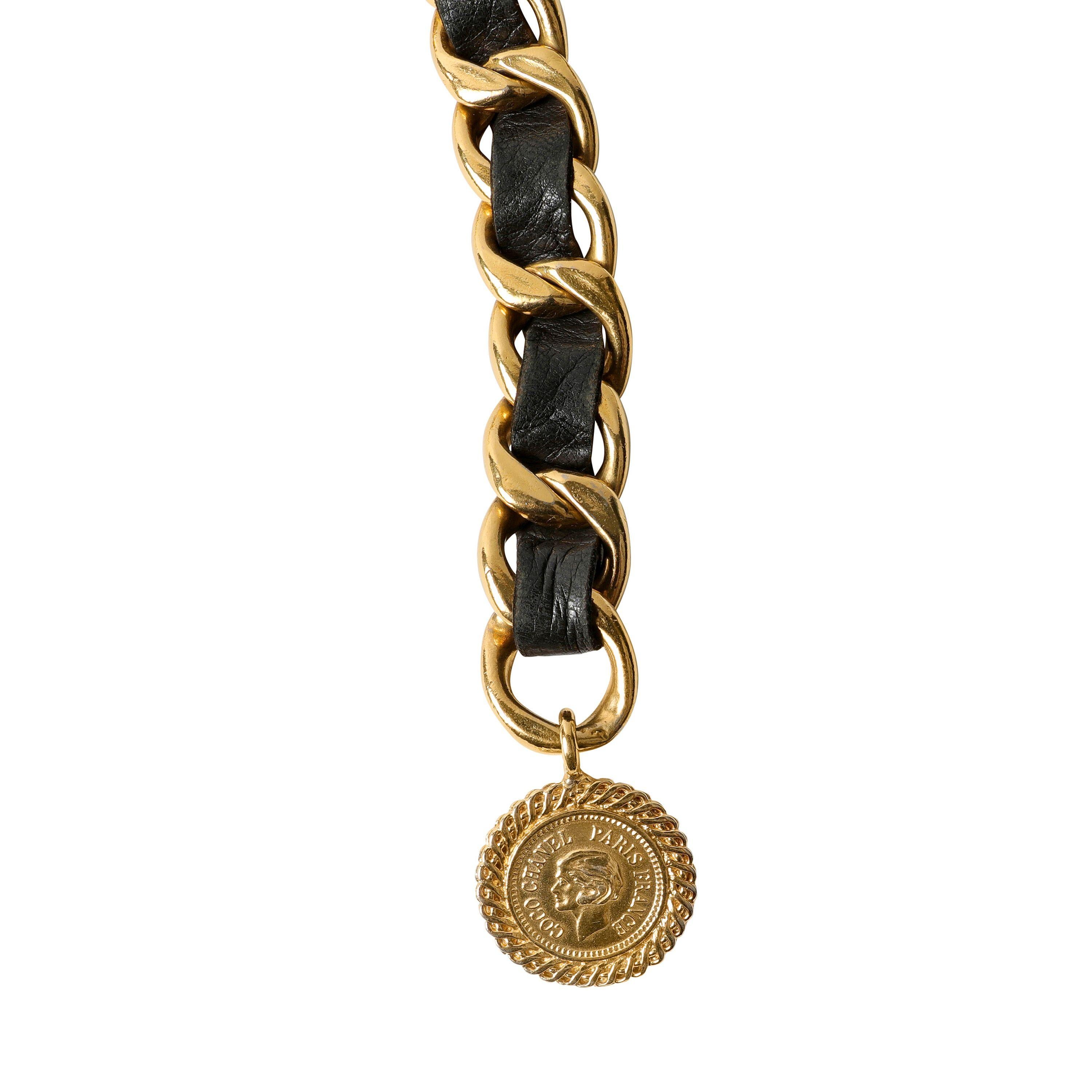Cette authentique ceinture en cuir noir et chaîne dorée de Chanel est en excellent état vintage.  Véritable classique, ce modèle à chaîne drapée est polyvalent et toujours chic. 
Le cuir noir est entrelacé avec une chaîne à maillons dorés.  Un grand
