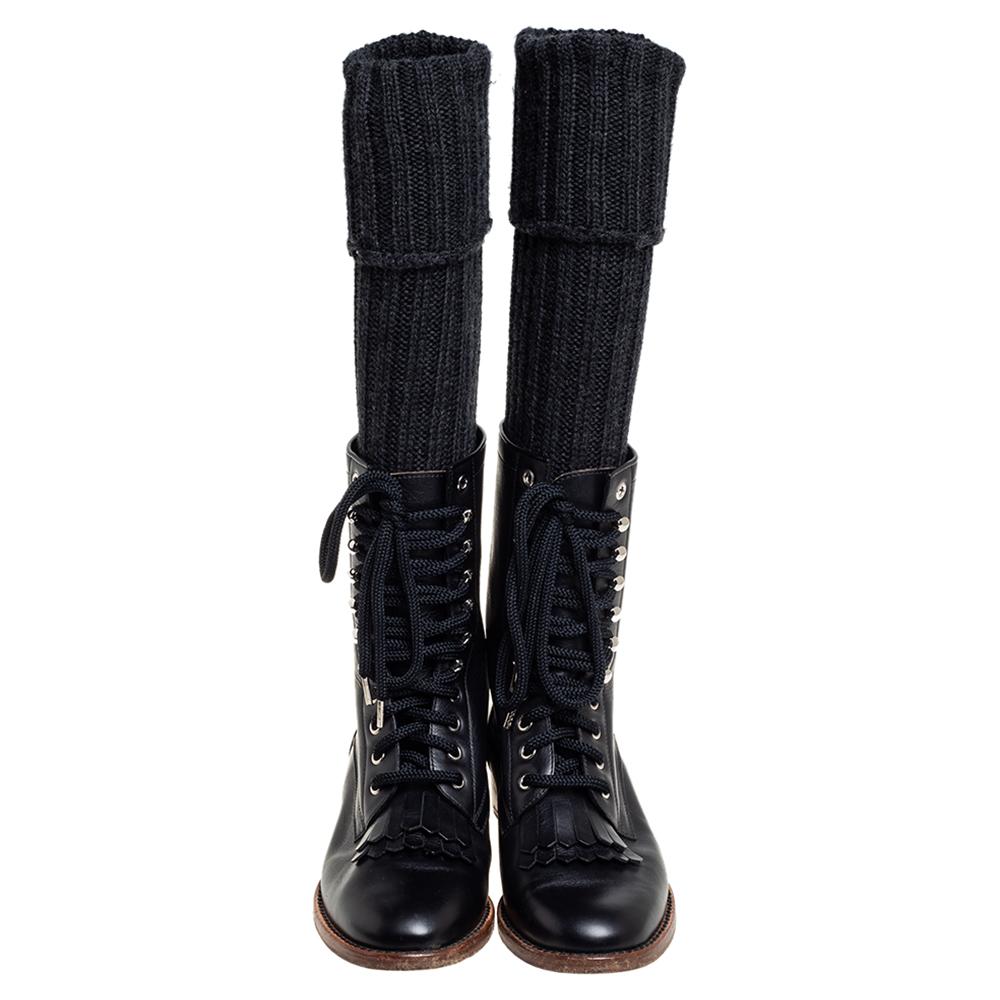 One can't help but love these boots from Chanel! Crafted from leather and styled in a sock design with knit fabric, these boots are on-point with style. They come with round toes, lace-up vamps with fringe detailing, and the CC logo on the side.