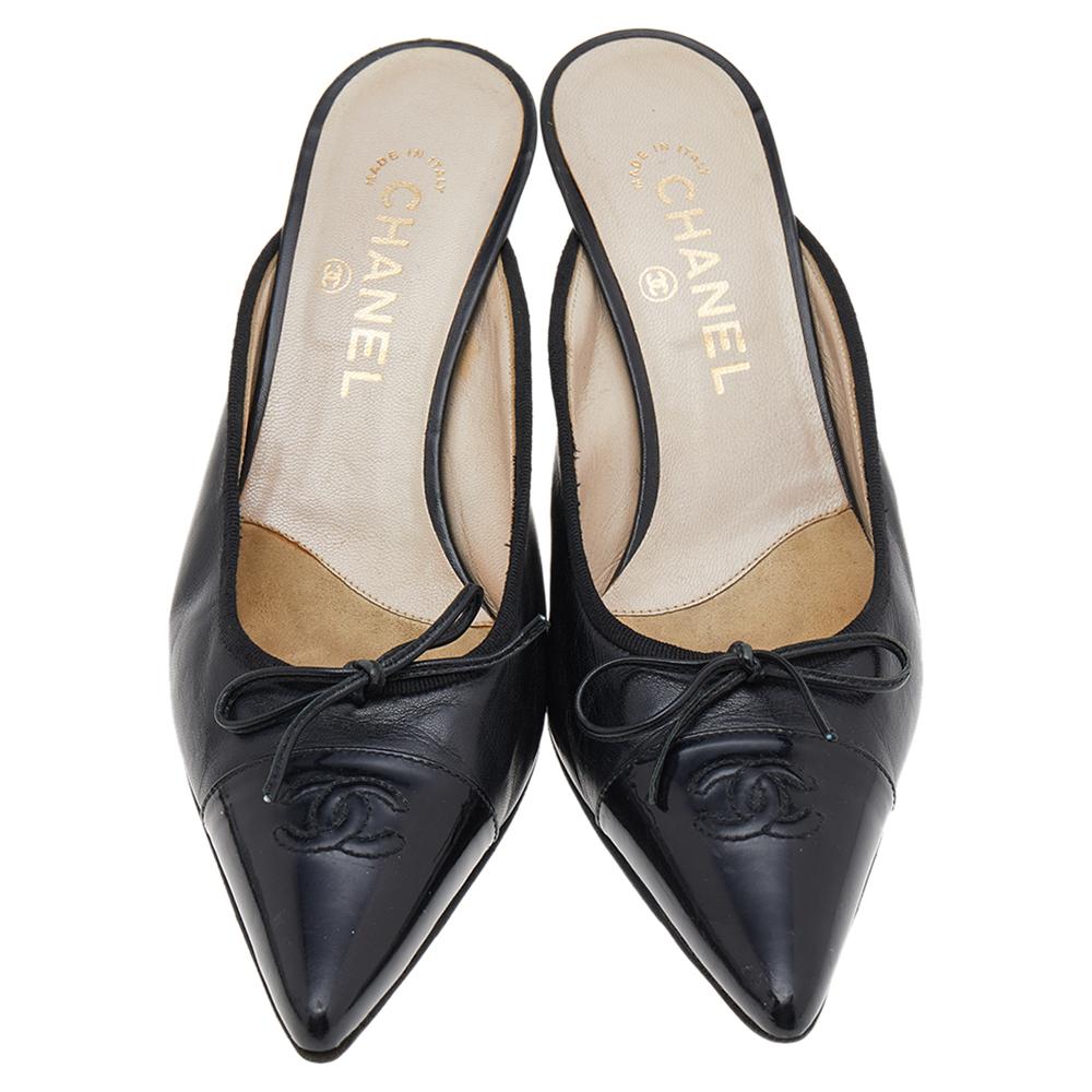 Experience comfortable ease all day in this pair of mules from Chanel. Crafted from black leather, they carry a signature design with pointed patent leather cap toes that come with the CC logo and easy-to-wear 7.5 cm heels.

