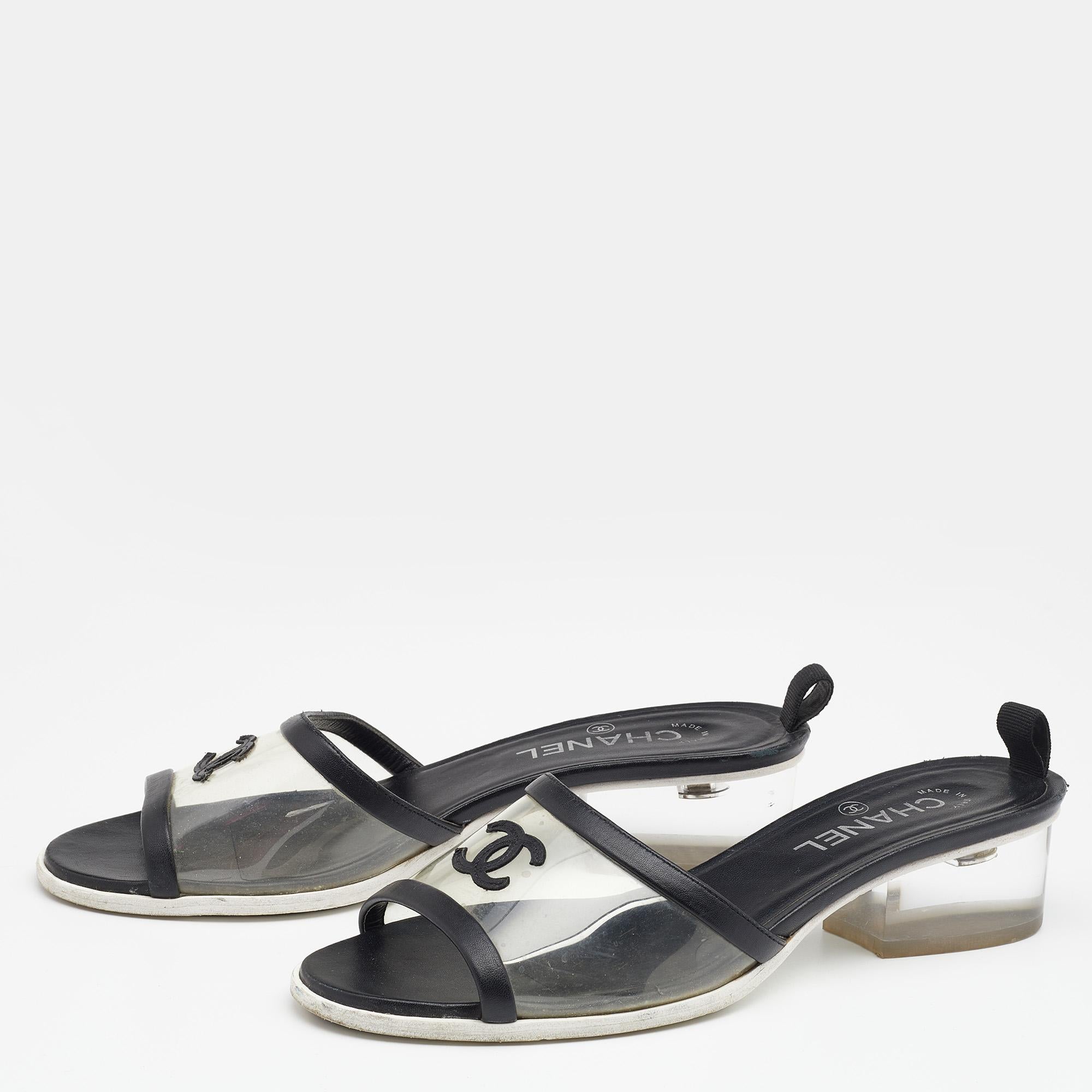 These slides from Chanel are simple and sophisticated. They are crafted from black leather and PVC, designed with open toes and CC logo-detailed vamp straps, and are endowed with smooth insoles. They stand on sturdy, clear block heels and tough