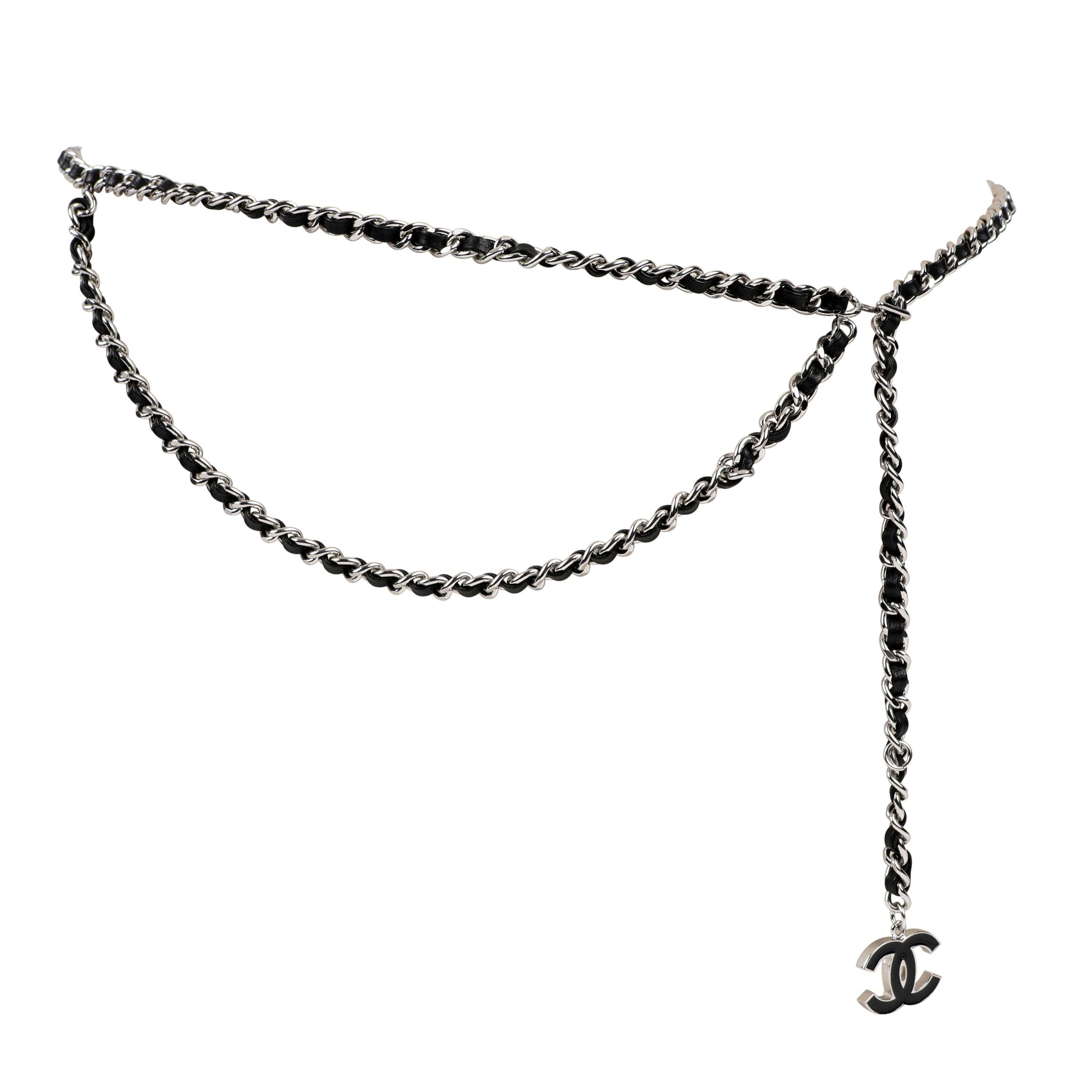 Cette authentique ceinture en cuir noir et chaîne argentée de Chanel est en excellent état.  Véritable classique, ce modèle à chaîne drapée est polyvalent et toujours chic.
Le cuir noir est entrelacé avec une chaîne à maillons argentés.  Un CC