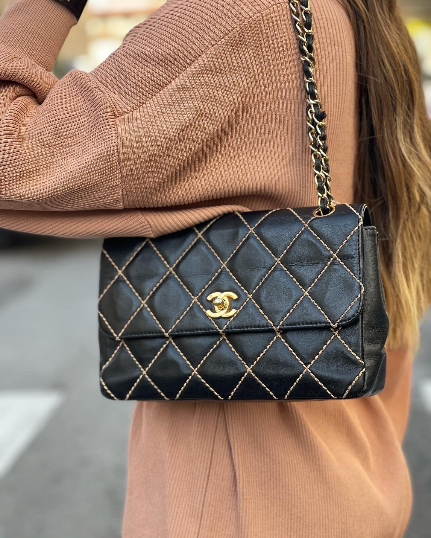 Chanel bag crafted in black leather with beige contrast stitching and gold hardware. Closure with classic CC logo, internally quite large and equipped with pockets. The bag is equipped with a leather shoulder strap and sliding chain. To be a product