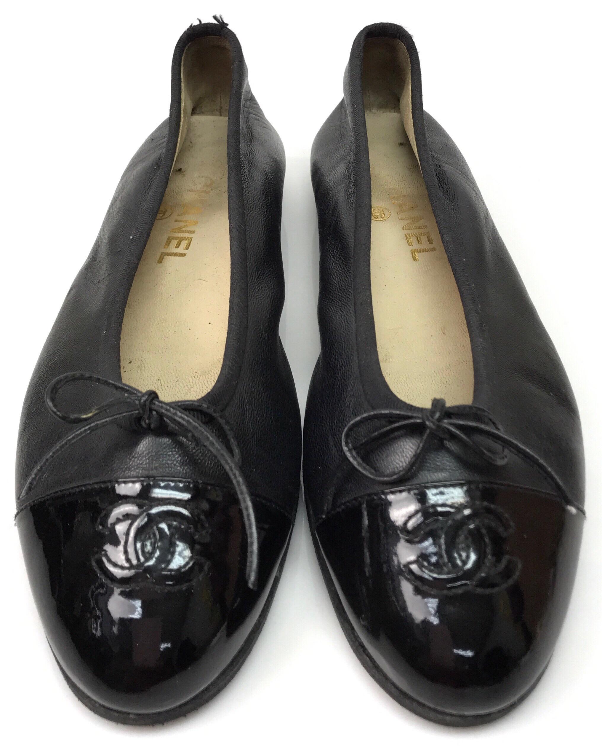 Chanel Black Leather Ballet Flats w/ Patent Toe & Bow-38.5. These adorable Chanel ballet flats are in good condition. They show wear consistent with age. The leather is slightly stretched and the bottoms are slightly rubbed off, the heel has been