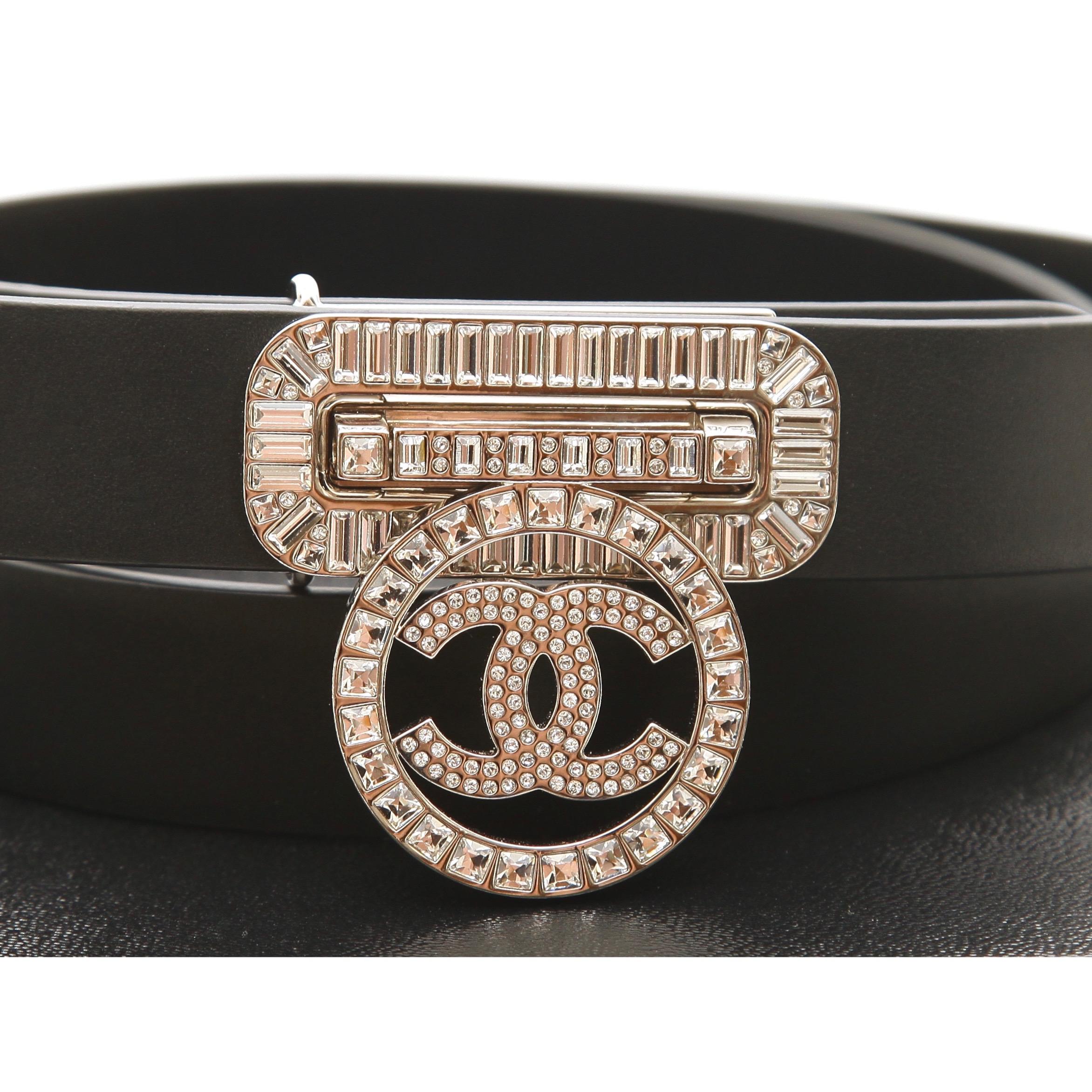 GUARANTEED AUTHENTIC CHANEL 2017 BLACK LEATHER BELT CRYSTAL CC CLOSURE

Details:
- Black leather waist belt.
- Front crystal CC logo buckle that slides into the crystal buckle opening and flaps down to close.
- 3 hole closure.
- Comes with Chanel