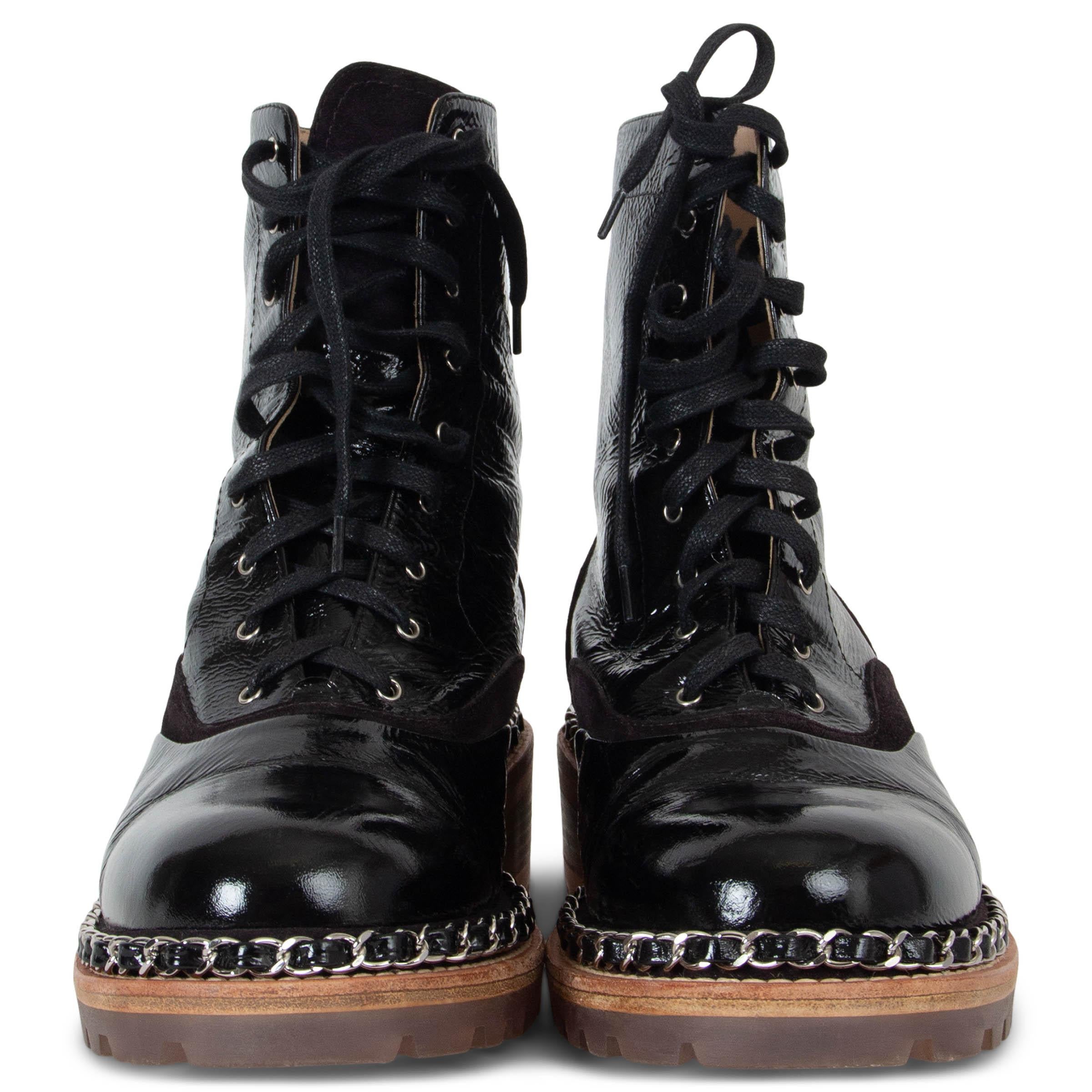 These 100% authentic Chanel lace-up combat boots in black crinkled patent leather with dark brown suede cut-outs blend edgy style with luxury craftsmanship. Designed with thick rubber soles featuring silver-tone leather interwoven chain trim, block