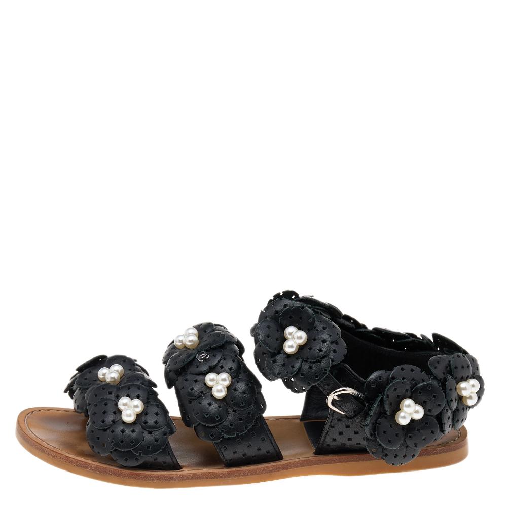 These sandals from the House of Chanel will grant your feet with unending poise and gracefulness. Made using black leather, they are adorned with the iconic Camellia and pearl embellishments on the upper. They showcase silver-toned hardware and a