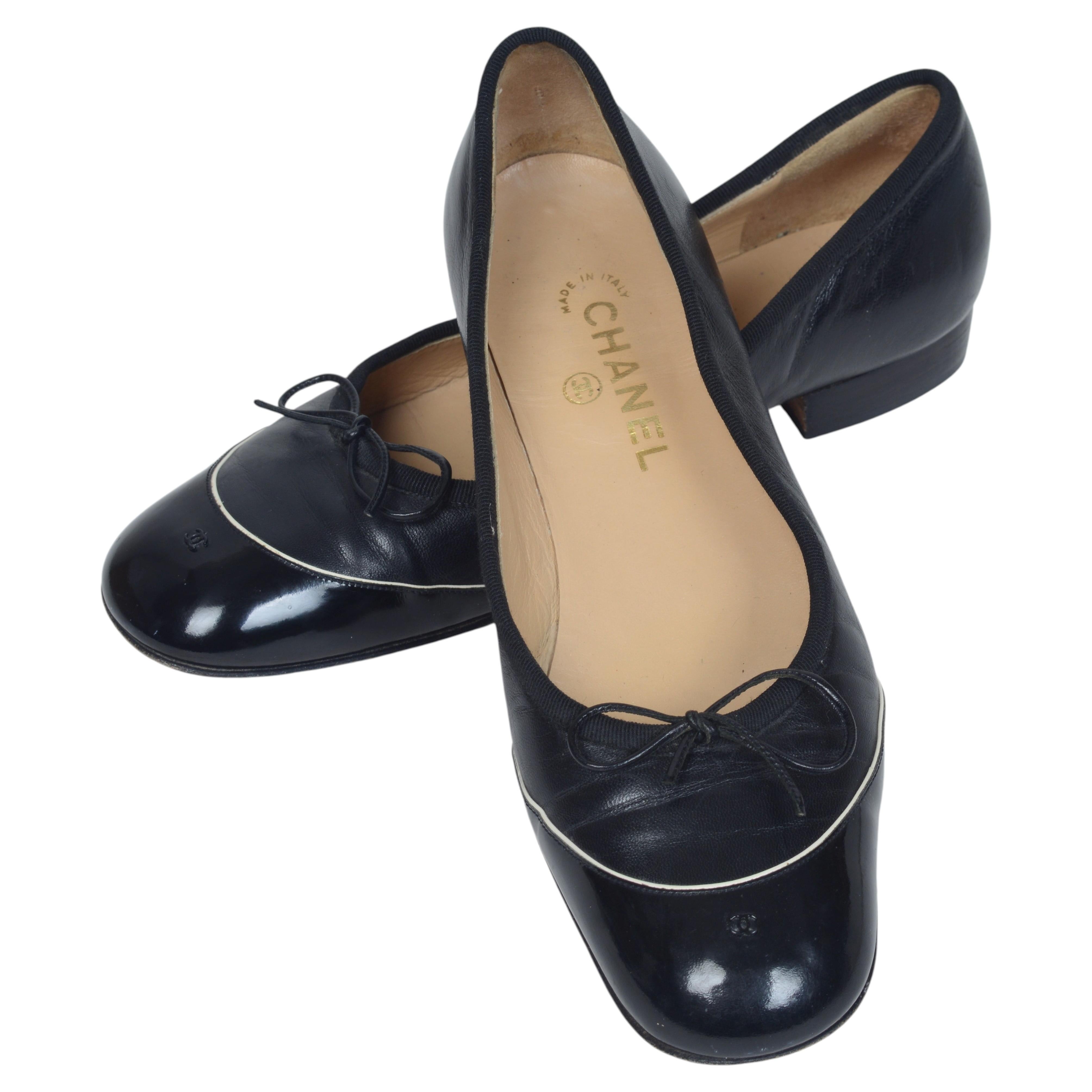 Ein Paar schwarze Chanel-Ballerinas mit Kappe und Schleife aus Lammleder und Lackleder
