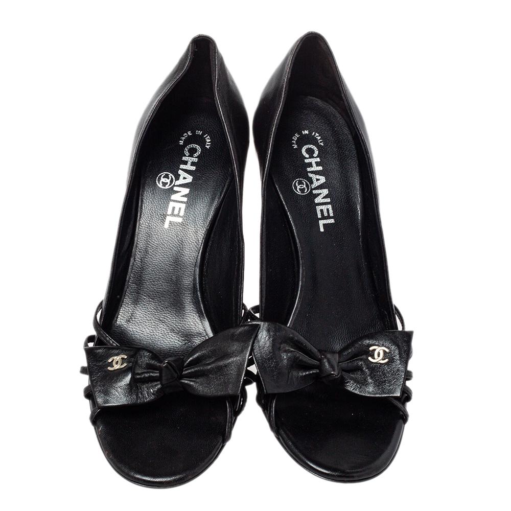Feminine, classy, and gorgeous, this pair of Chanel pumps is a must-have. Their fun design is crafted from leather in a black hue. They feature open-toed vamps detailed with CC logo adorned bows. This pair of beauties features 9 cm heels and leather