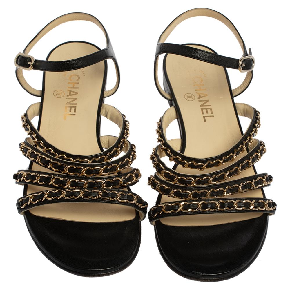 Bring in the subtle glamour to your outfits with this pair of sandals from Chanel. They have been crafted from black leather and styled with three slender straps at the front accented with interwoven chain details. These sandals come with buckled
